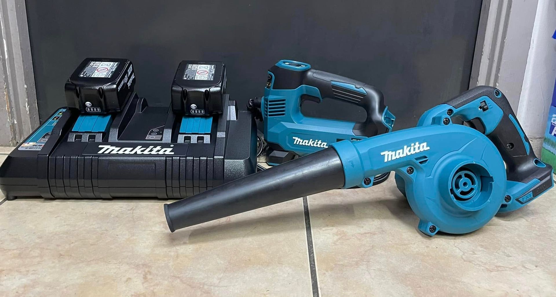 A Makita Dual-port Battery Charger With Two Batteries, a Cordless Jigsaw, and a Blower — Ingham Agencies in Ingham, QLD