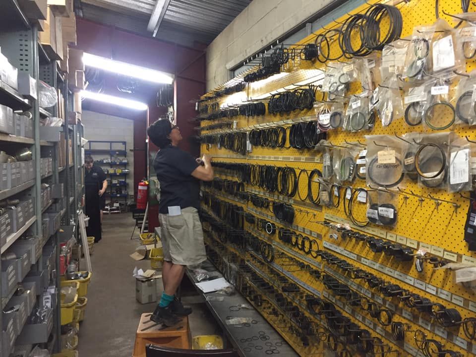A Person Stands on a Small Step Stool to Reach Items on a Wall — Ingham Agencies in Ingham, QLD