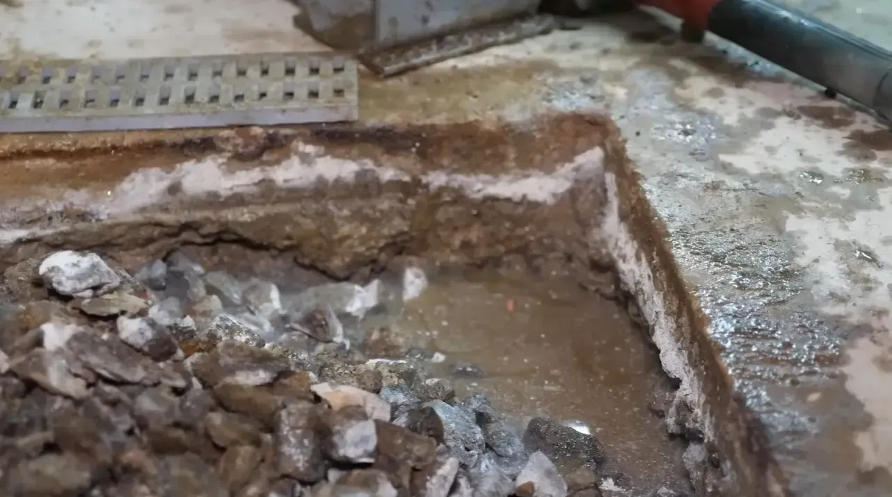 Basement trench drain installation during foundation waterproofing repair