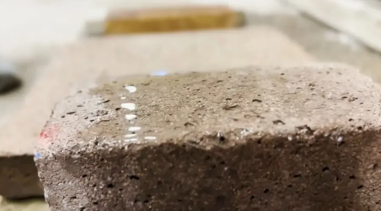 Close-up of a concrete block showing water droplets on the surface illustrating how concrete is porous to water and absorbs moisture