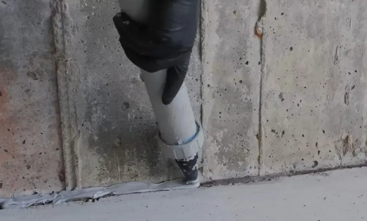 Close-up of cove joint repair using sealant to fill the gap where the basement foundation wall meets the concrete slab floor
