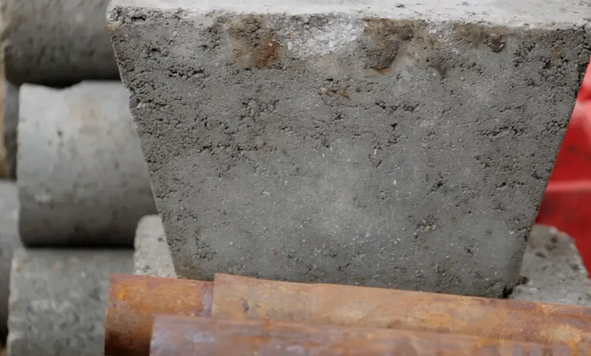 Concrete pier block set beside steel pipe illustrating concrete piers vs steel piers for foundation support