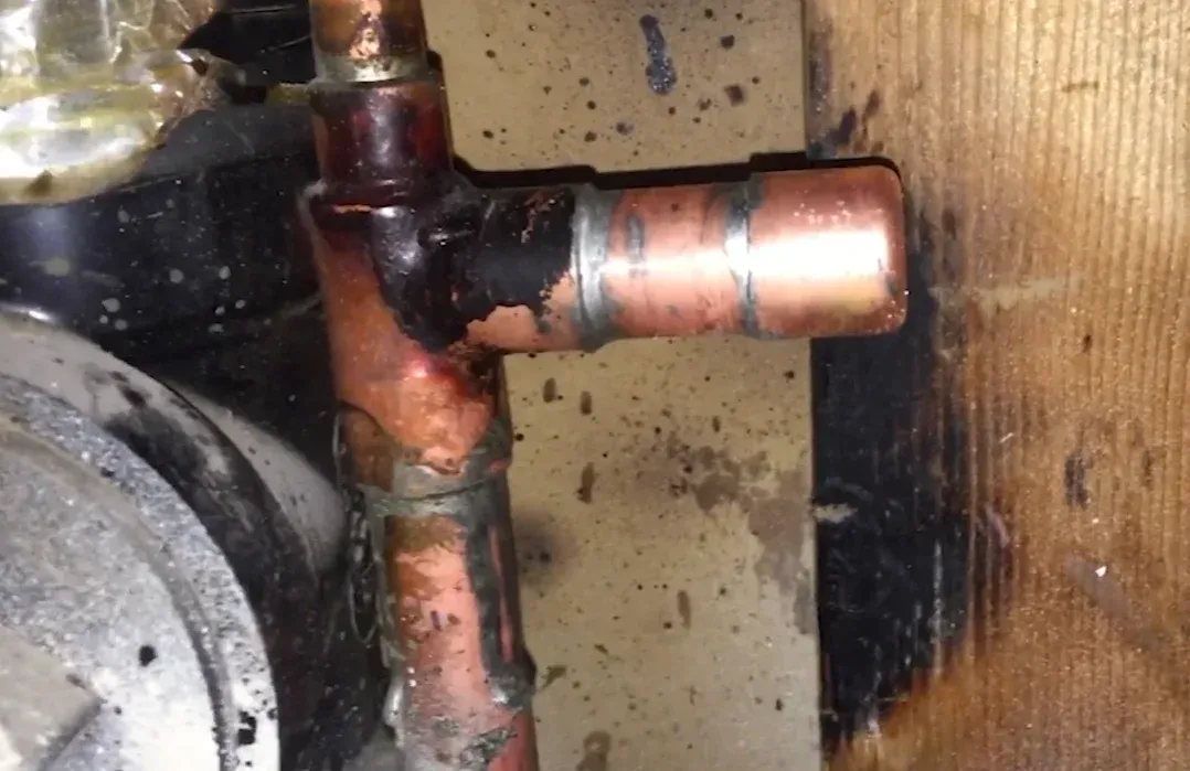Corroded copper pipe fittings with visible mineral buildup under a home, a common warning sign uncovered through slab leak repair and detection