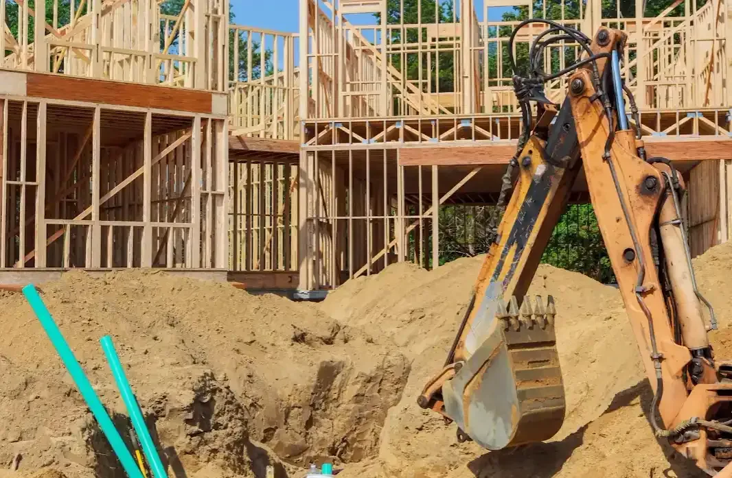 Excavator working loose backfill soil around a new foundation where the clay bowl effect can develop