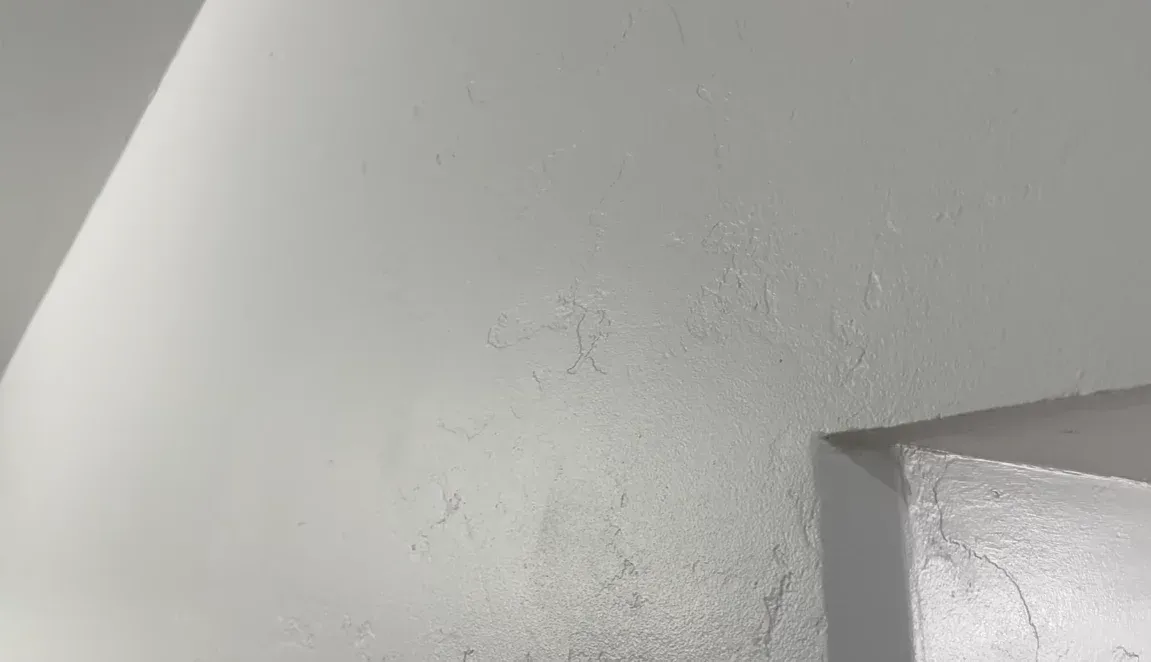 Hairline drywall cracks on an interior wall showing early warning signs that call for wall crack repair and foundation stability inspection