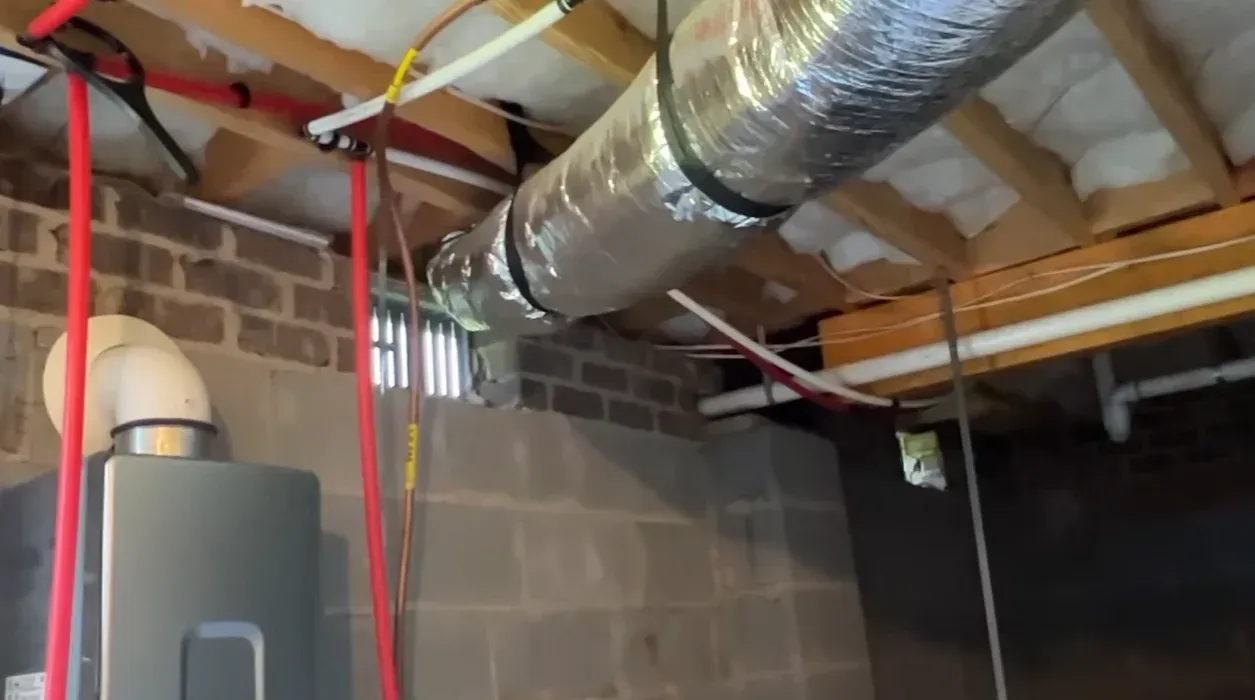 Insulated ductwork and plumbing lines inside a block wall crawl space where crawl space dehumidifiers help protect against moisture damage