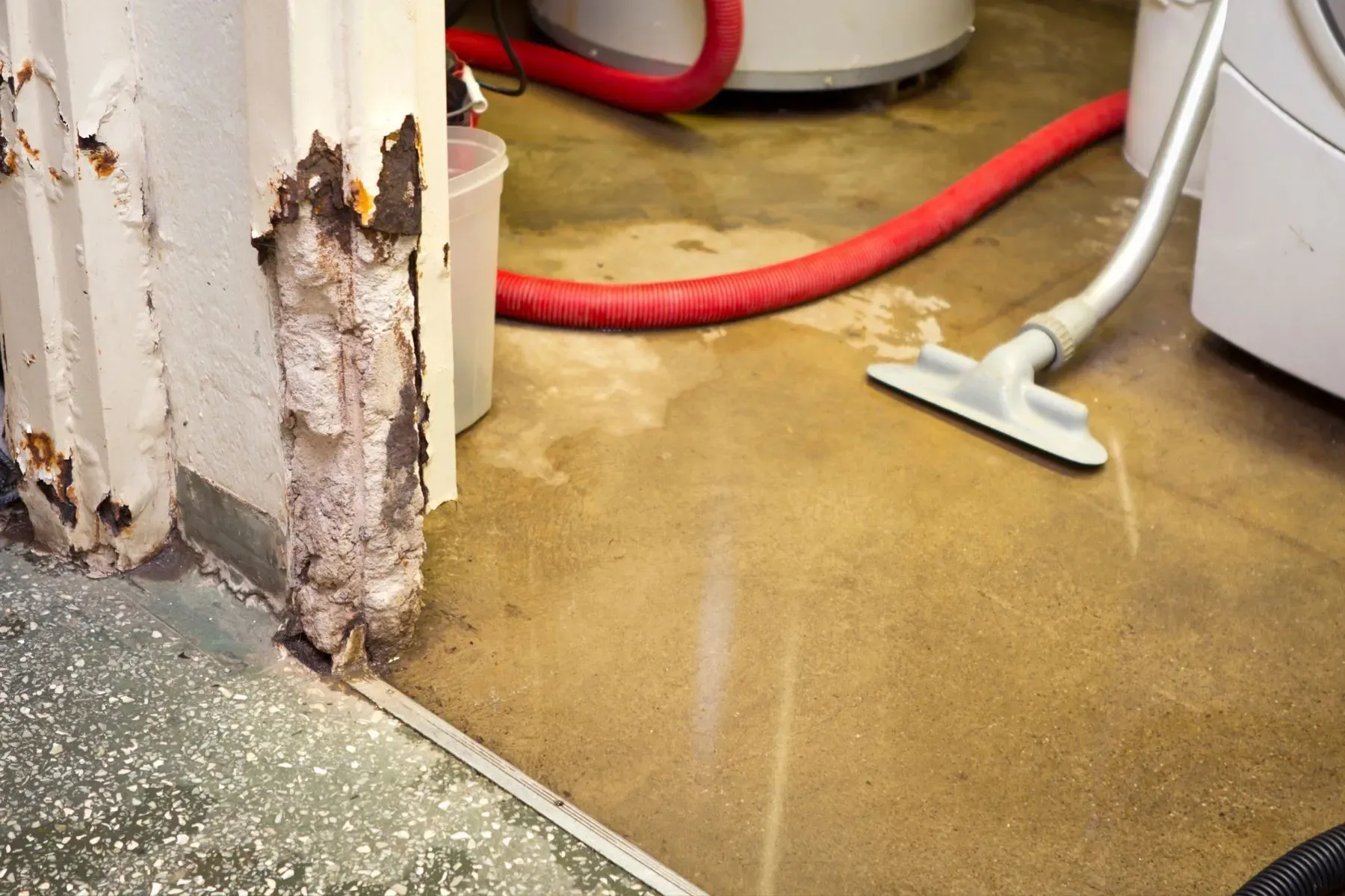 Flooded basement interior with murky standing water covering the floor near a staircase after heavy rainfall.