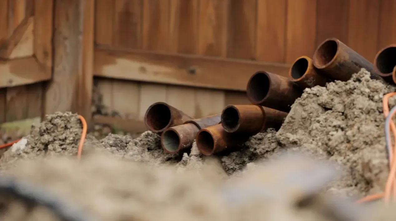 Stacked steel pier pipe sections showing surface rust before foundation installation