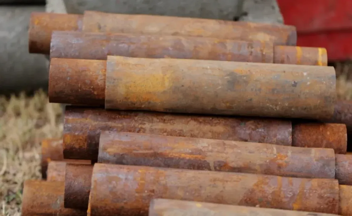 Stacked steel pier pipe sections showing surface rust before foundation installation