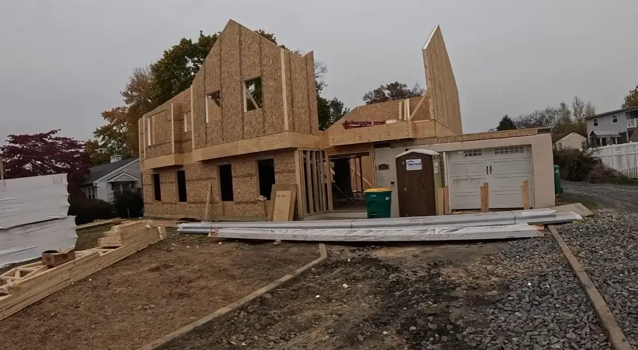 Wood framed new home under construction with floor and wall sheathing on a residential lot