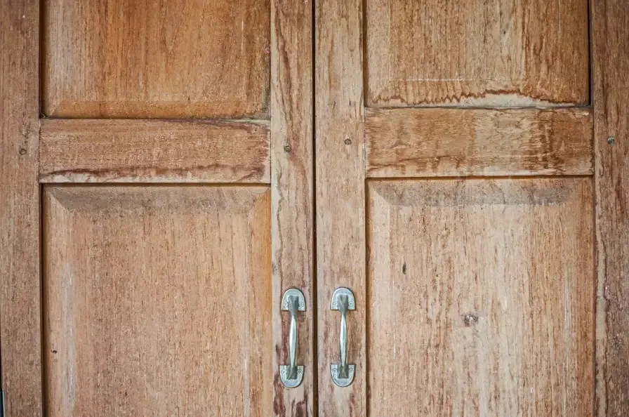 Wooden cabinet doors sticking shut from foundation settling in an older home