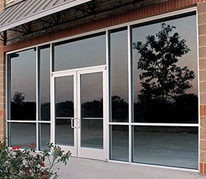 A building with a lot of windows and a tree reflected in the windows