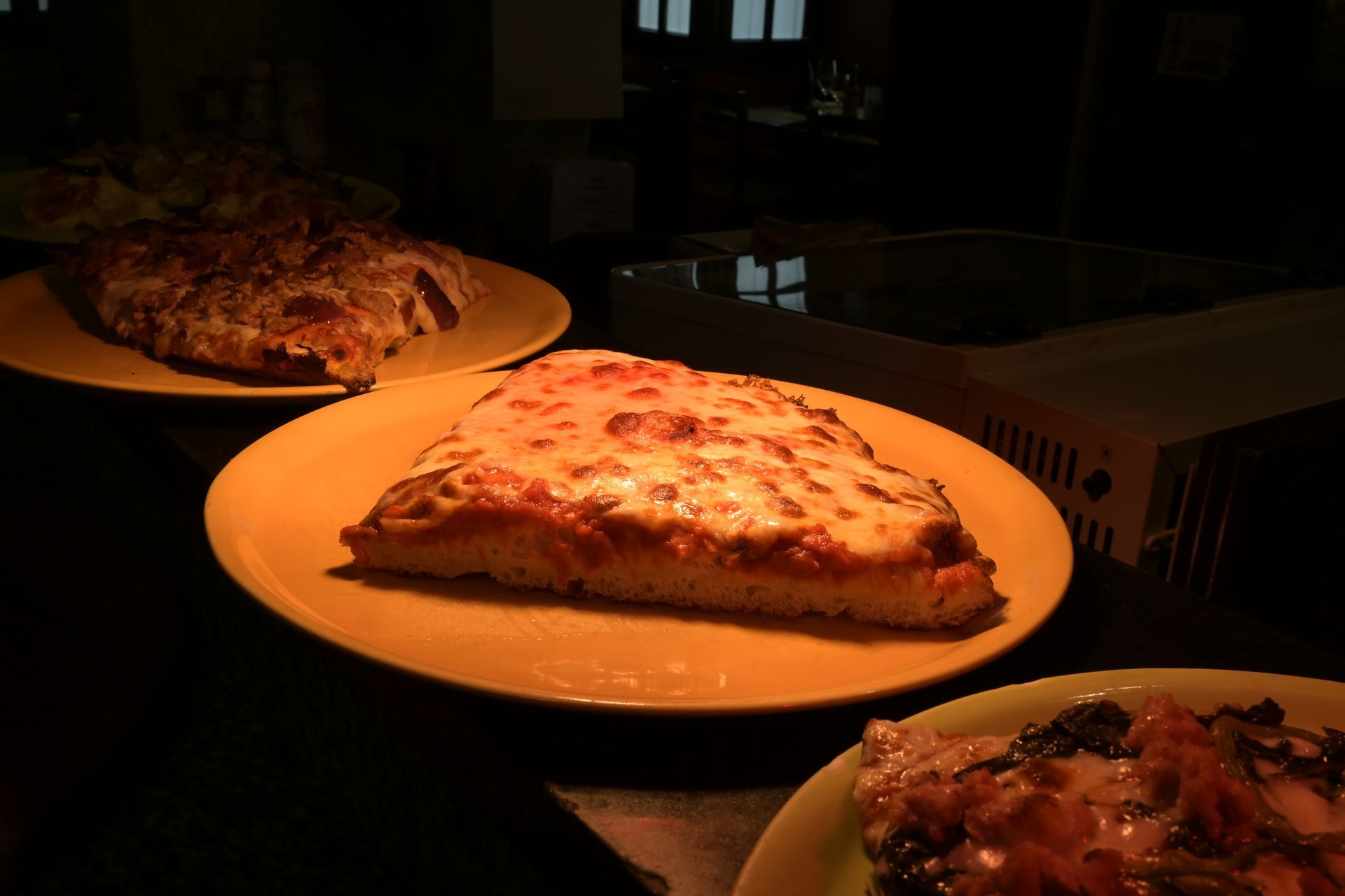 Fette di pizza nei piatti, con una luce calda e soffusa