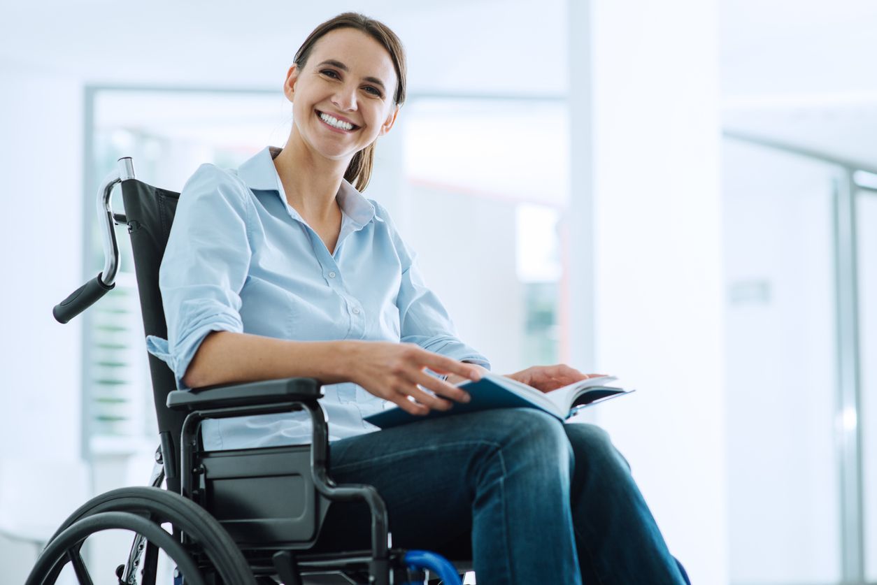 Woman in a wheelchair smiling in a bright office setting