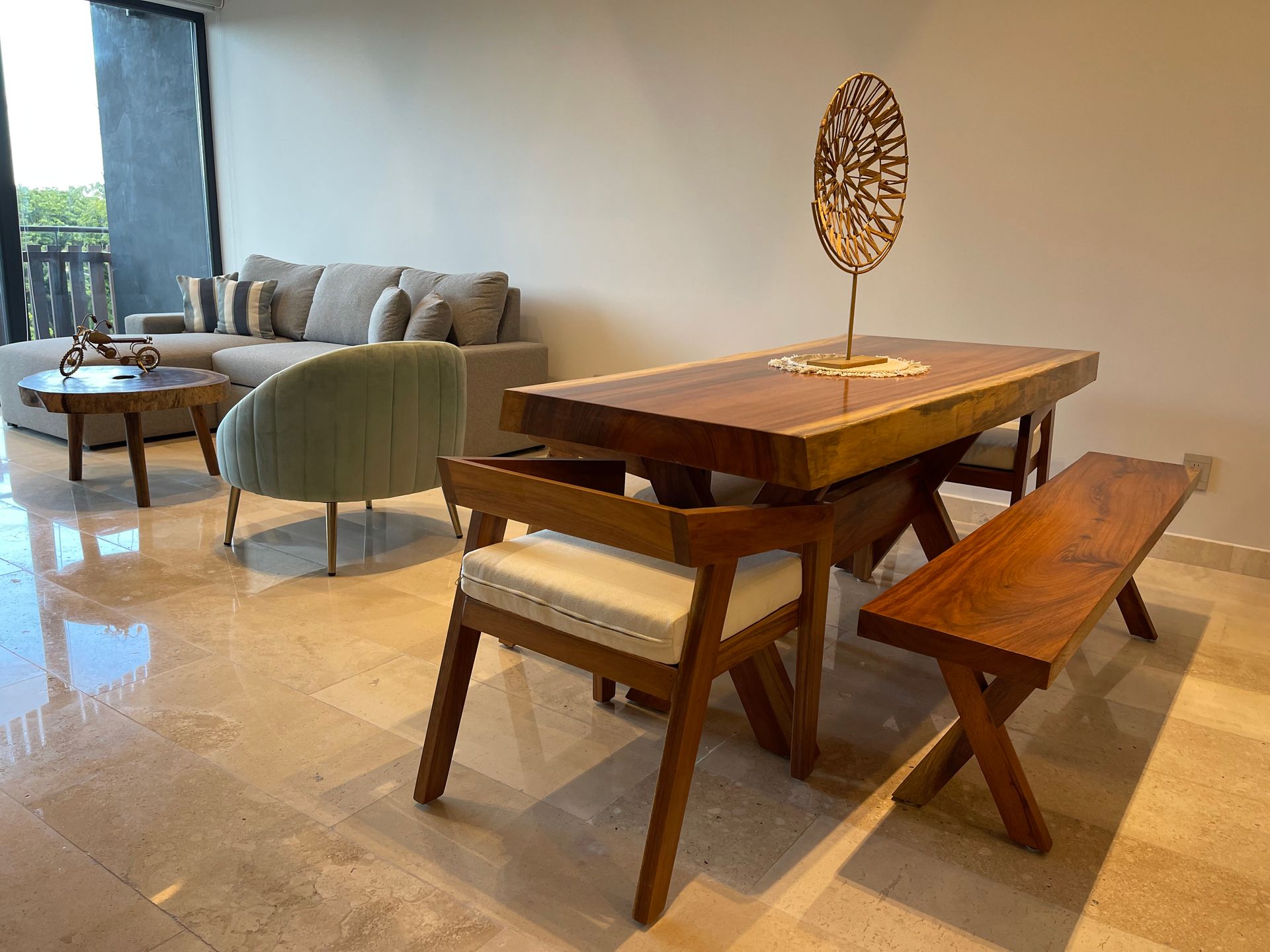 Sala de estar con mesa de comedor de madera, sofá y silla verde claro.