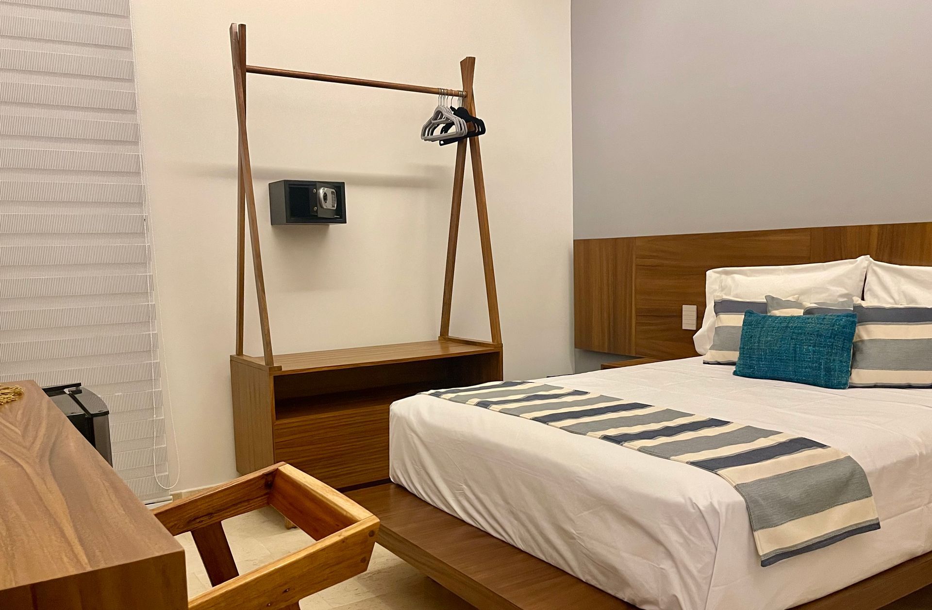 Dormitorio con muebles de madera, cama, armario y caja fuerte en la pared.