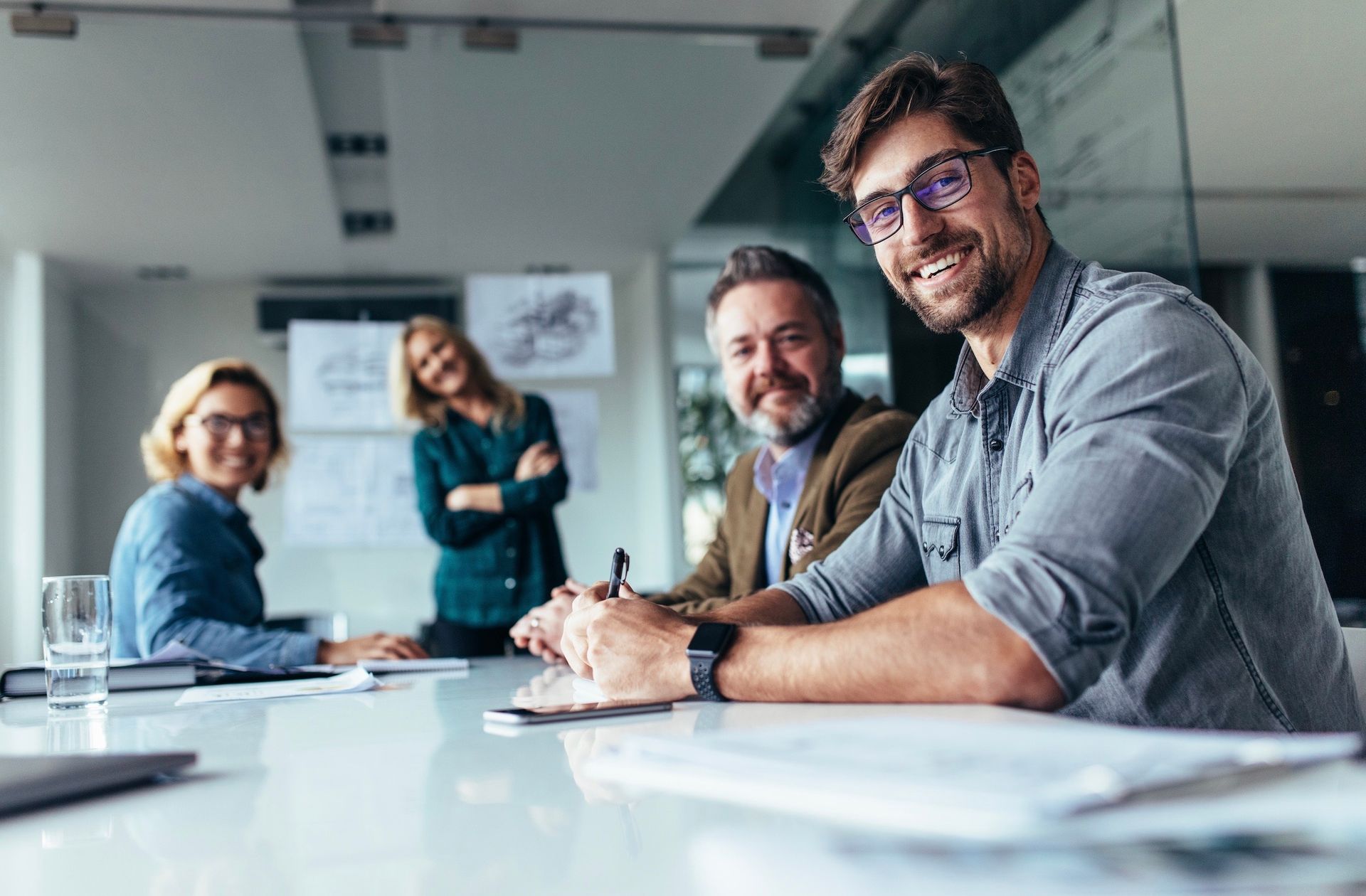 A group of people are sitting around a table in a conference room.