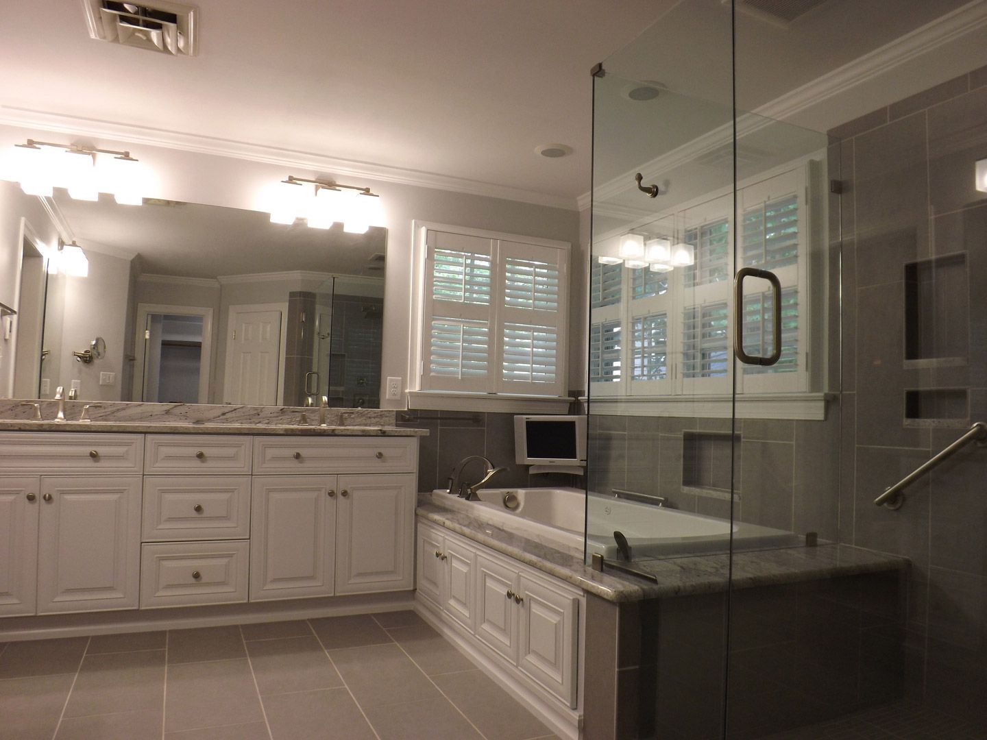 A bathroom with two sinks a tub and a walk in shower