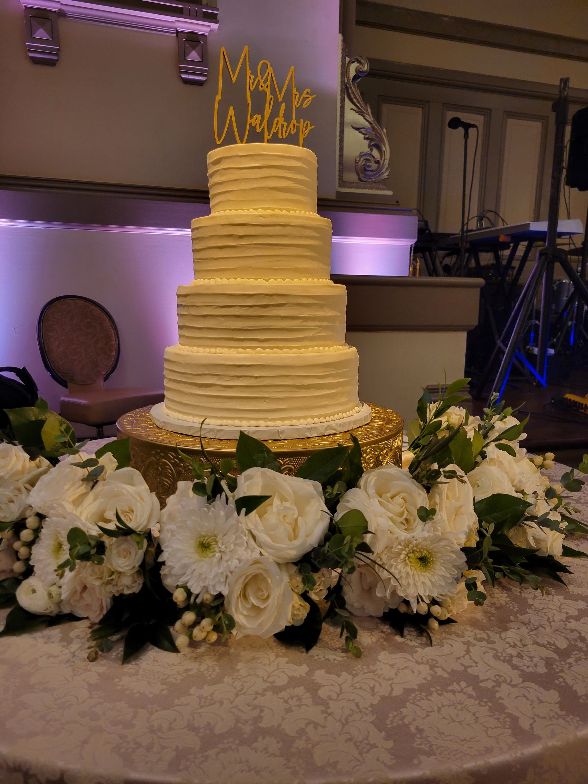A wedding cake is sitting on top of a table with flowers.