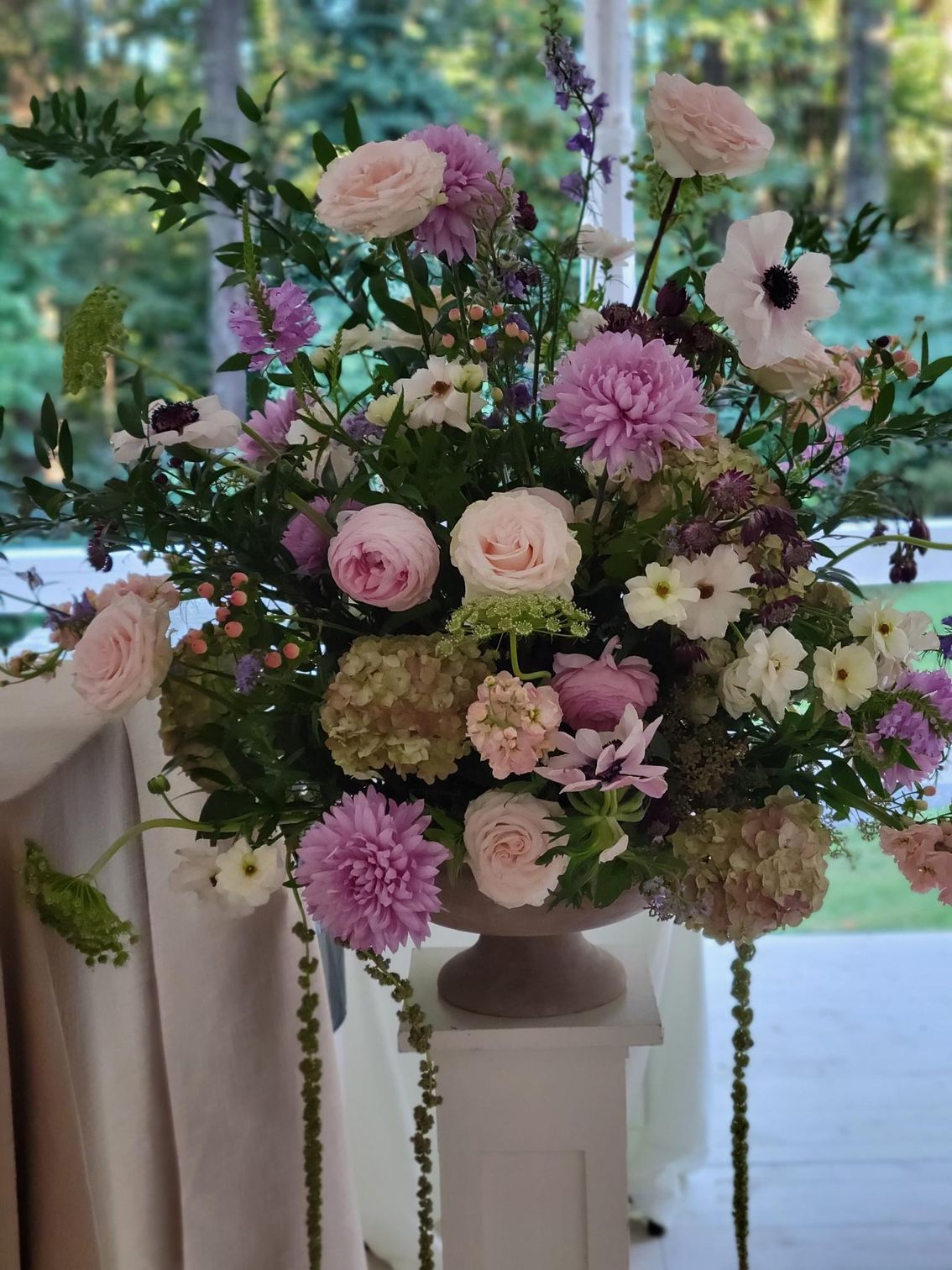 A vase filled with purple and white flowers is sitting on a table.