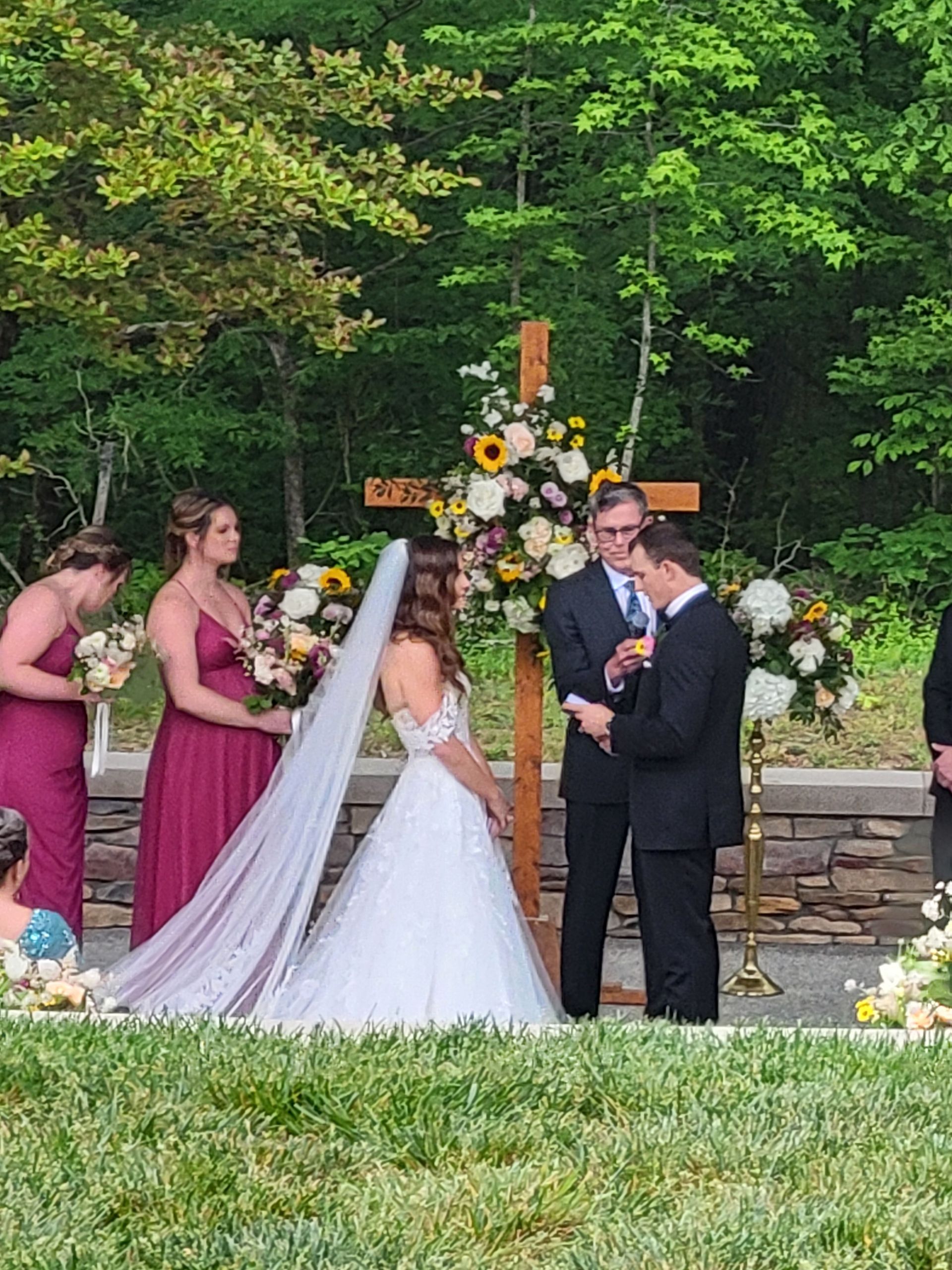 A bride and groom are getting married in front of their wedding party.