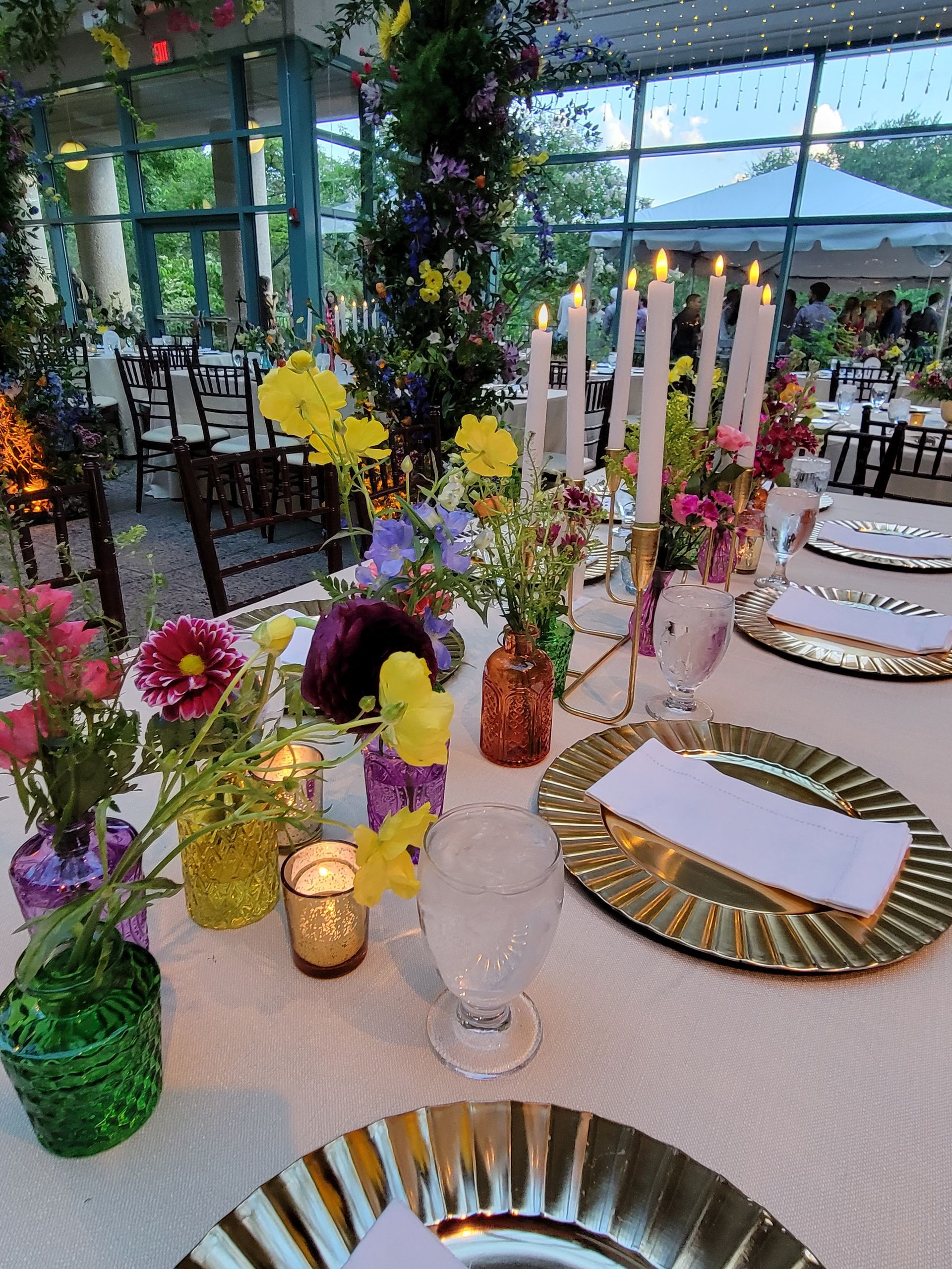 A table with plates , candles , and flowers on it.