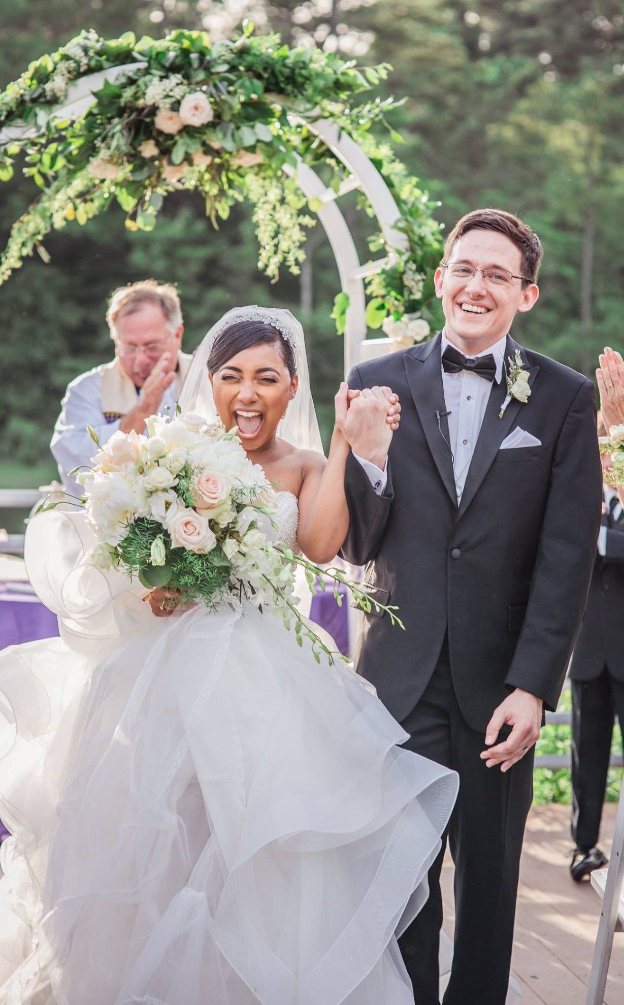 A bride and groom are walking down the aisle at their wedding holding hands.