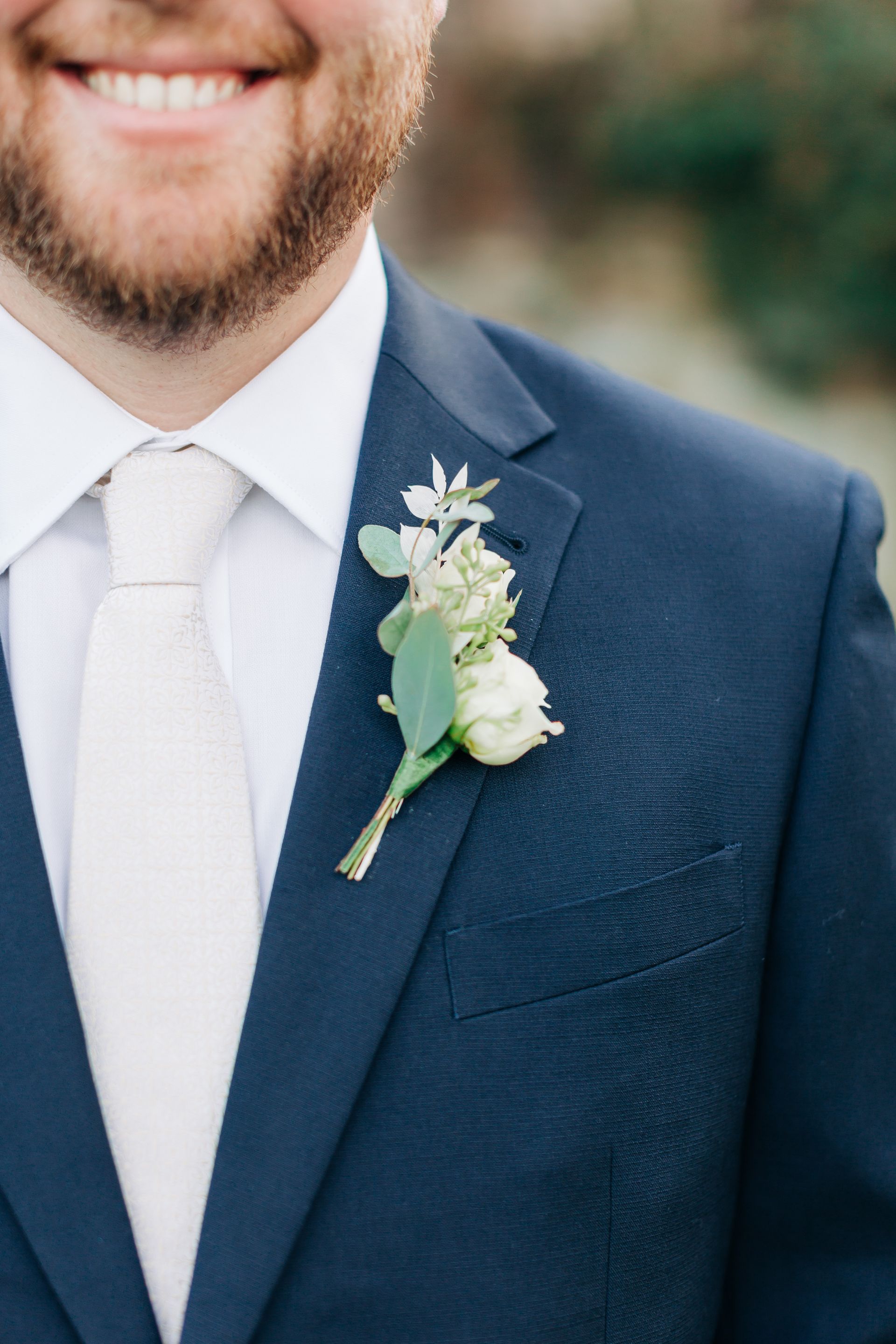 A man in a suit and tie with a flower in his pocket.