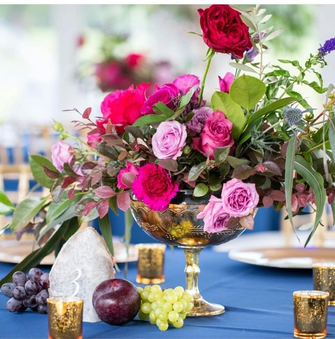 A vase filled with pink and red flowers sits on a table