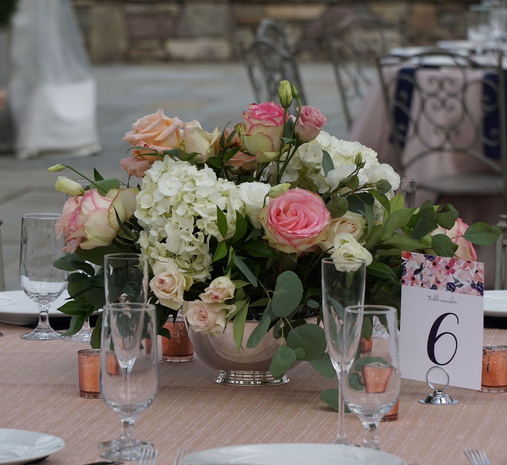 A table setting with a vase of flowers and a table number 6