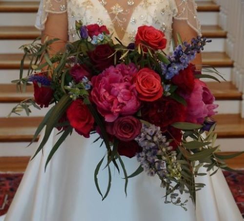 A woman in a white dress is holding a bouquet of flowers