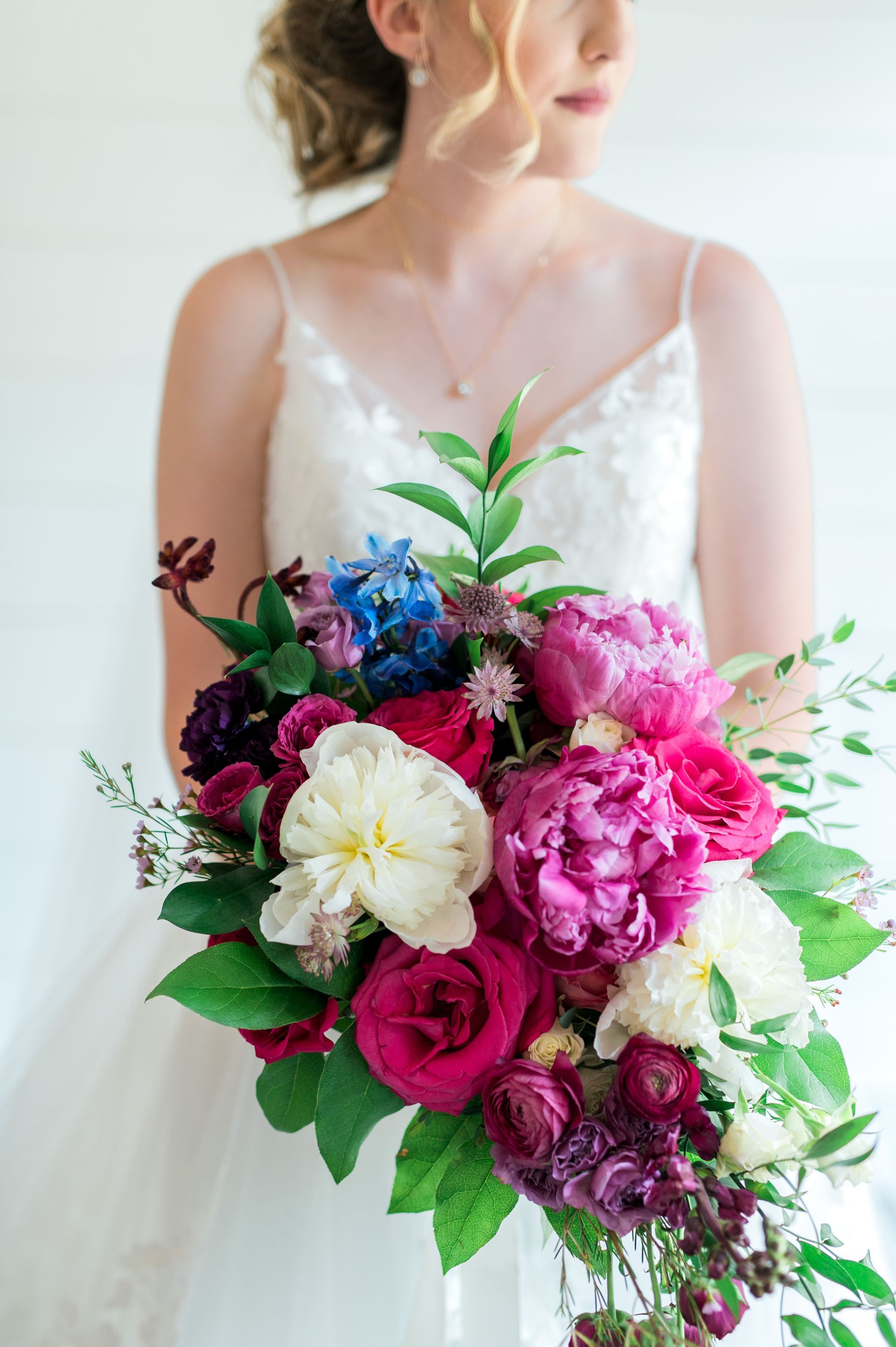 A bride in a white dress is holding a bouquet of flowers.