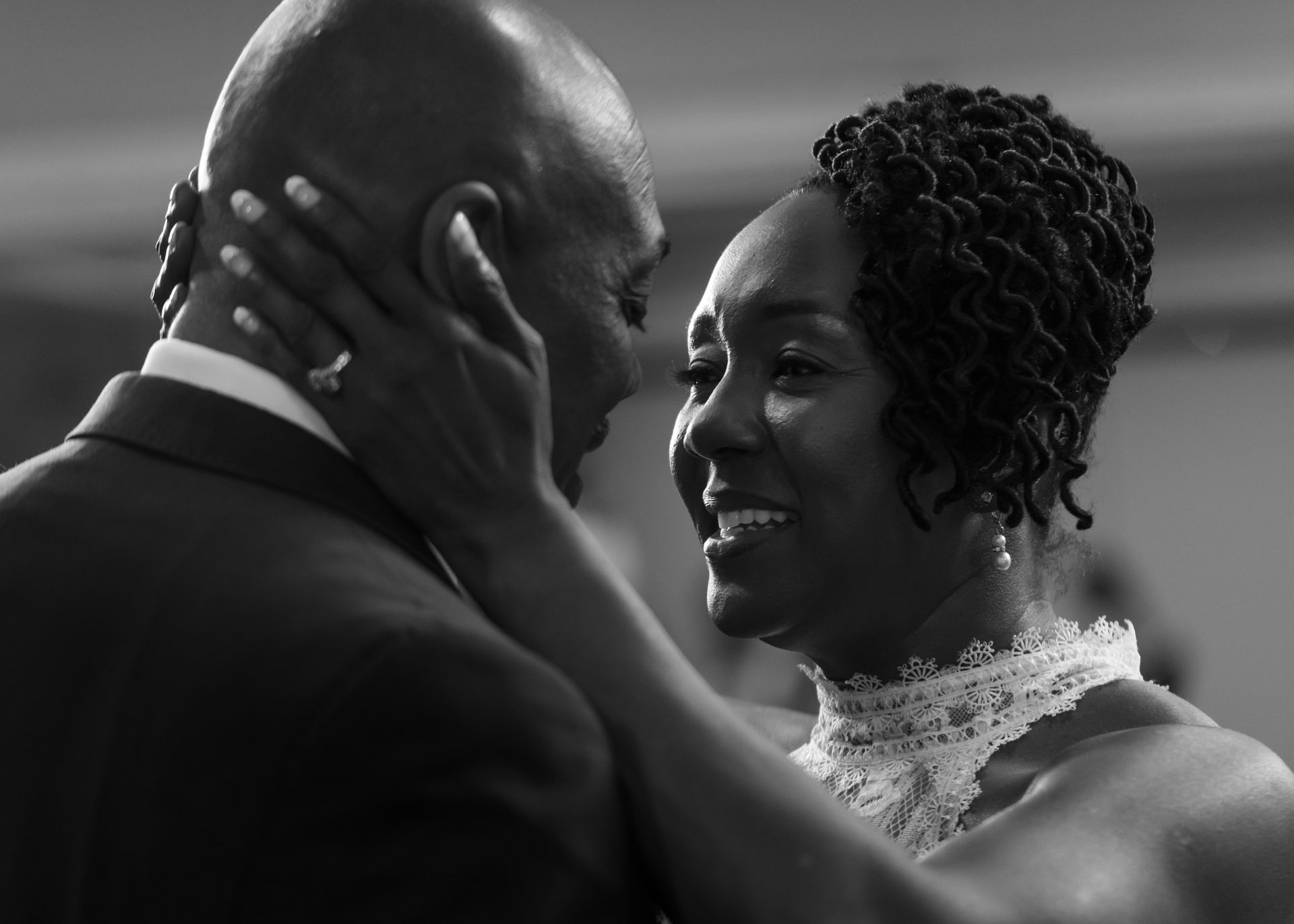 A black and white photo of a bride and groom dancing.