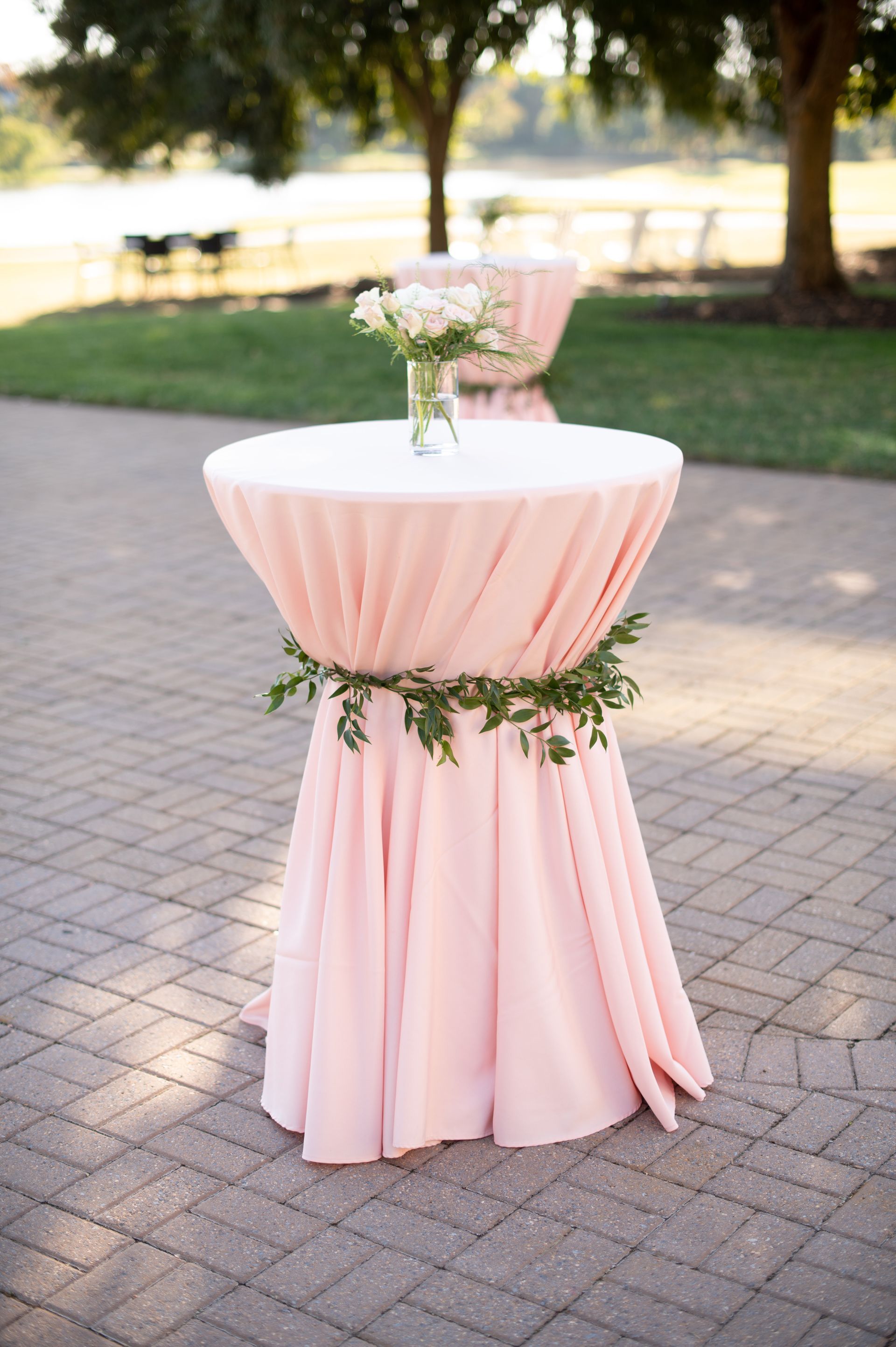 A table with a pink table cloth and flowers on it.