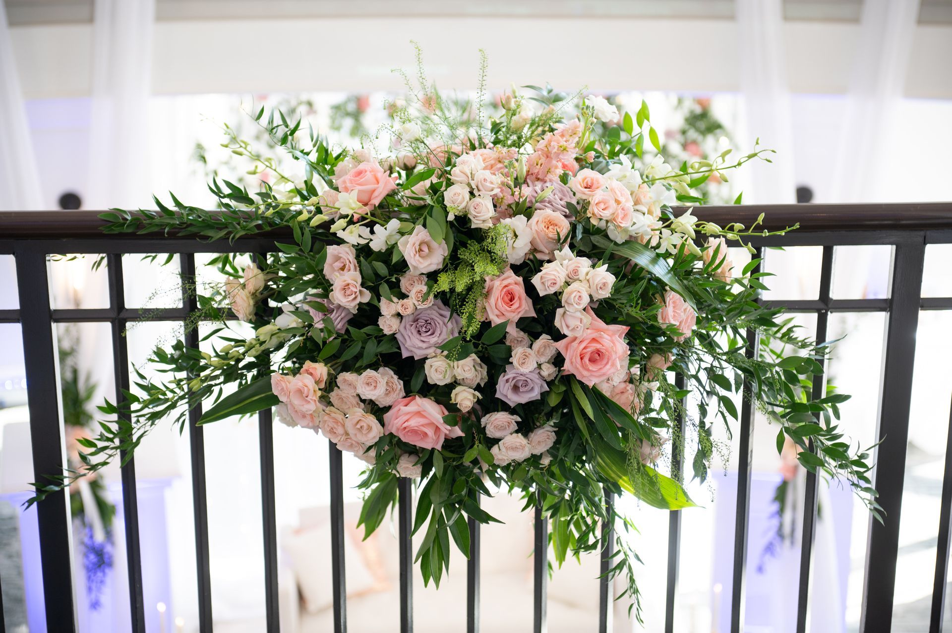 A large bouquet of flowers is hanging from a railing.