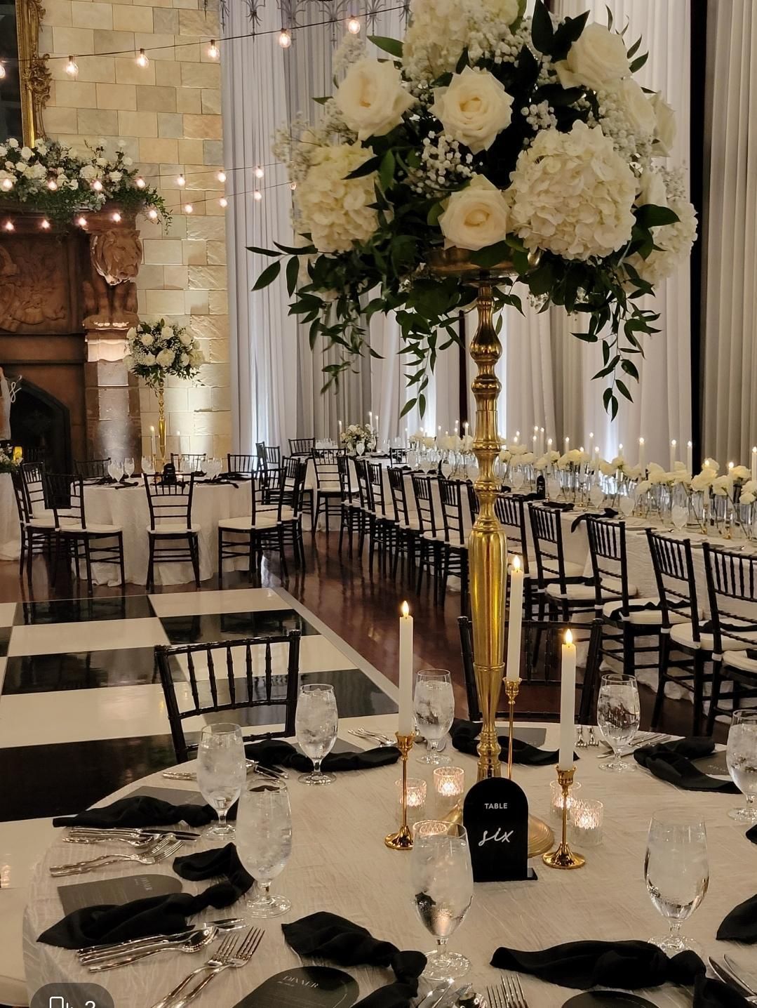 A table with a vase of flowers and candles on it