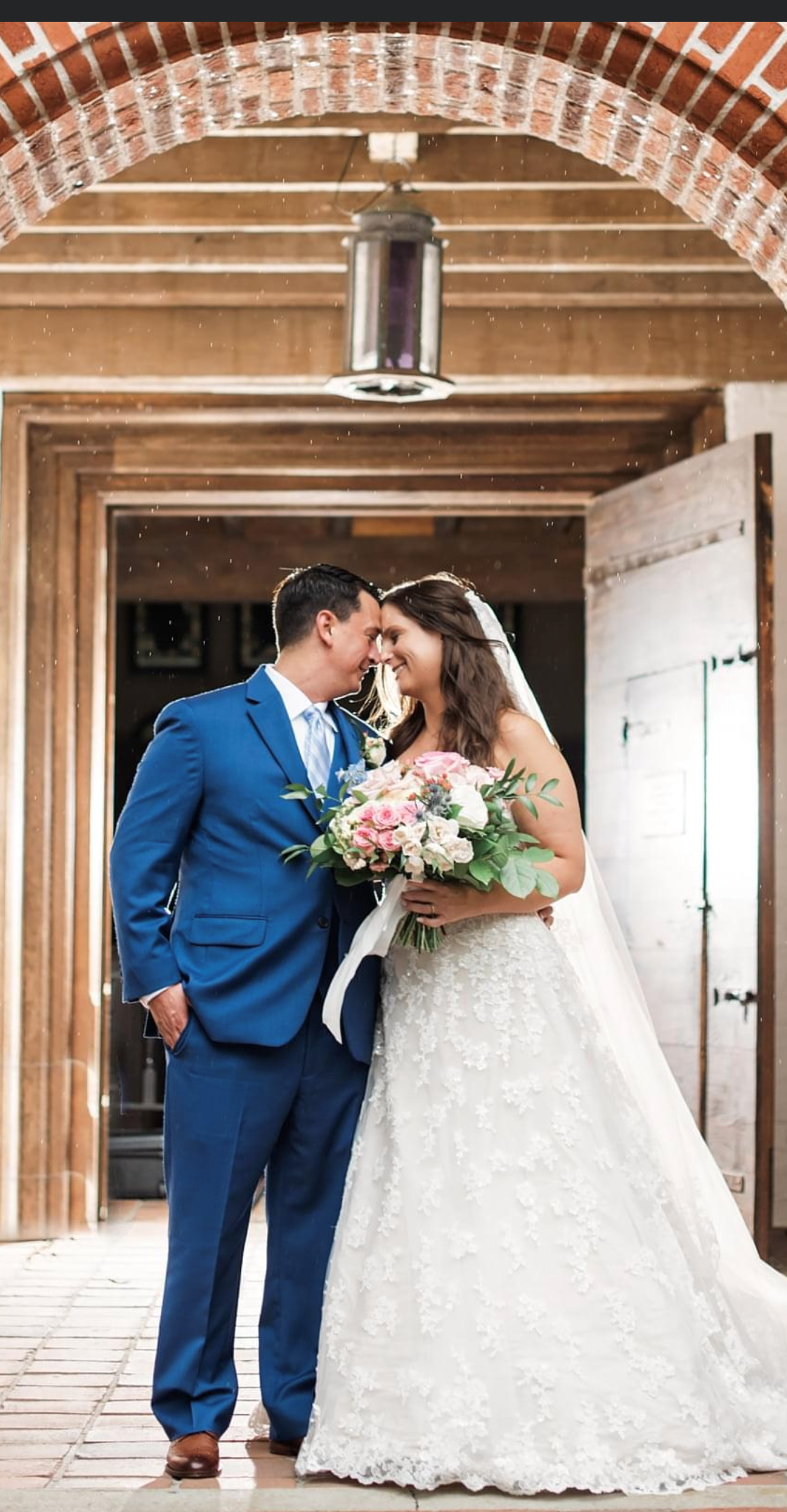 A bride and groom are kissing in front of a church door.