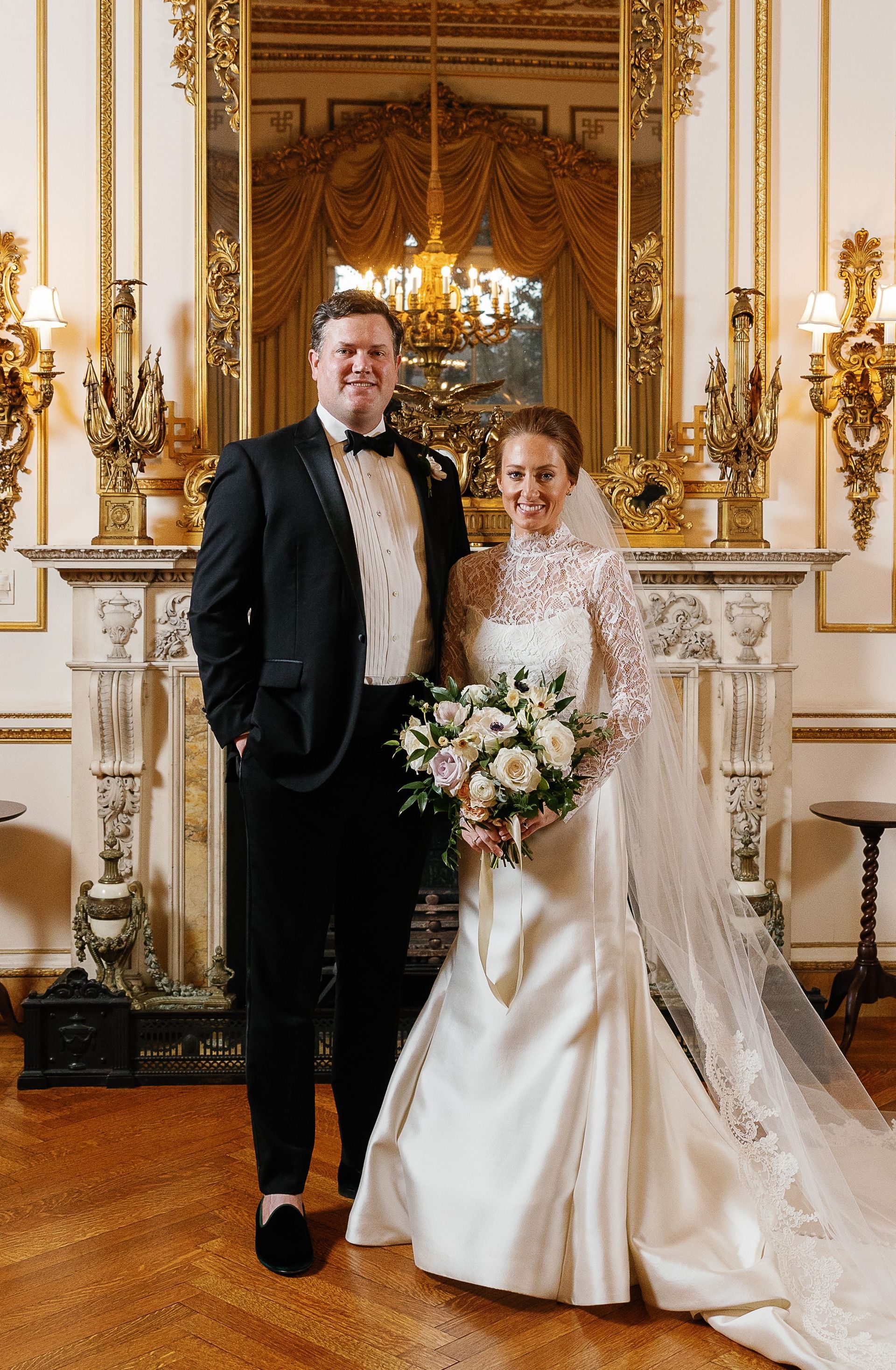 A bride and groom are posing for a picture in front of a fireplace.