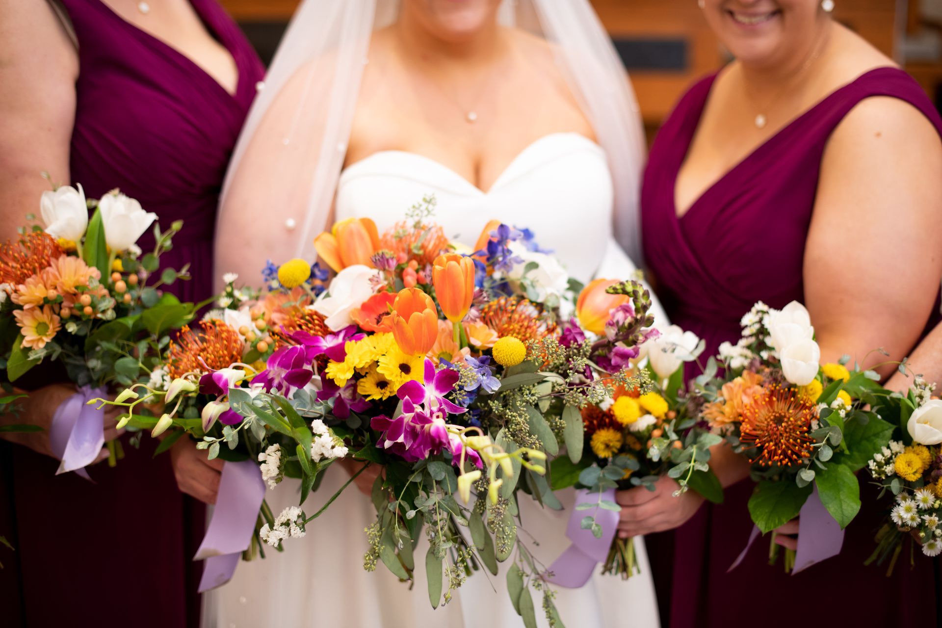 A bride and her bridesmaids are holding bouquets of flowers.