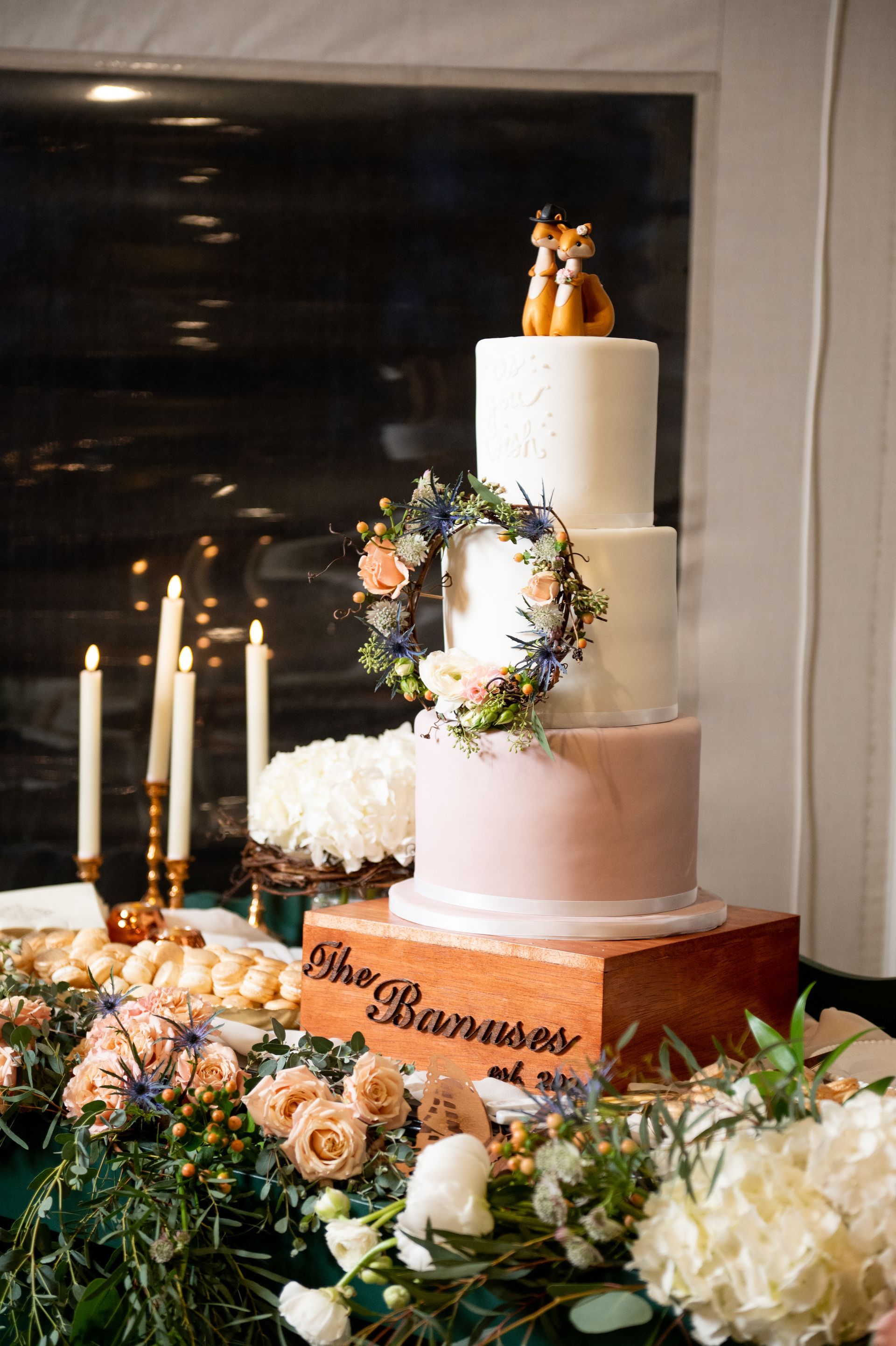 A wedding cake is sitting on top of a wooden box on a table.