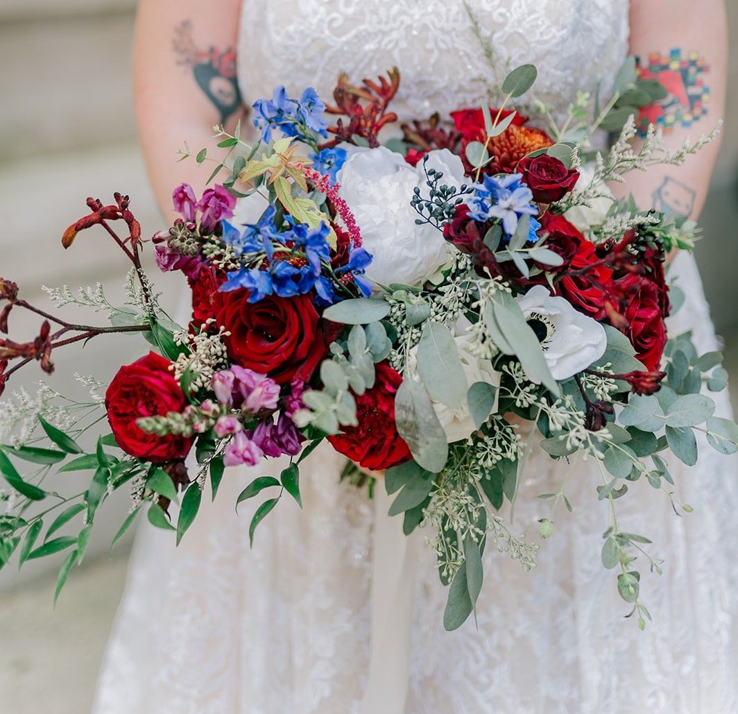 A woman in a white dress is holding a bouquet of flowers.