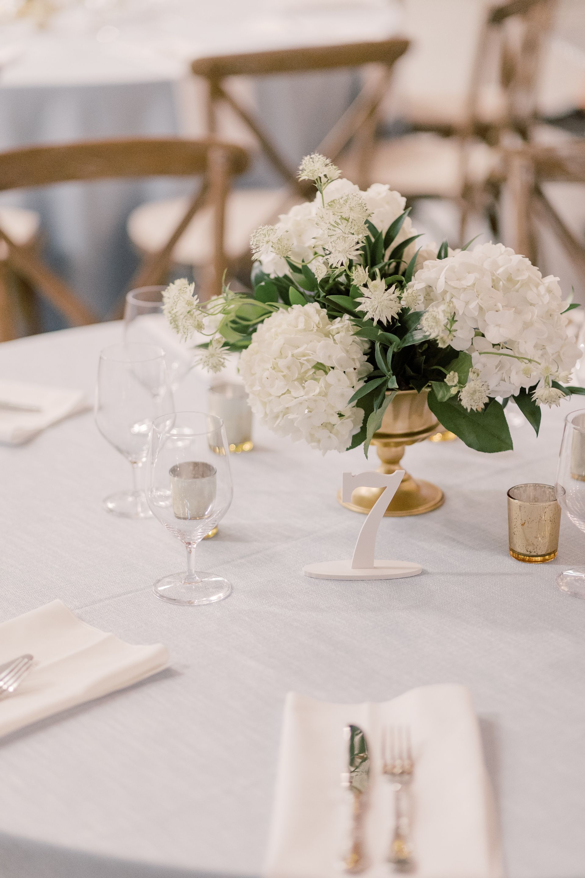 A table with a vase of white flowers on it.