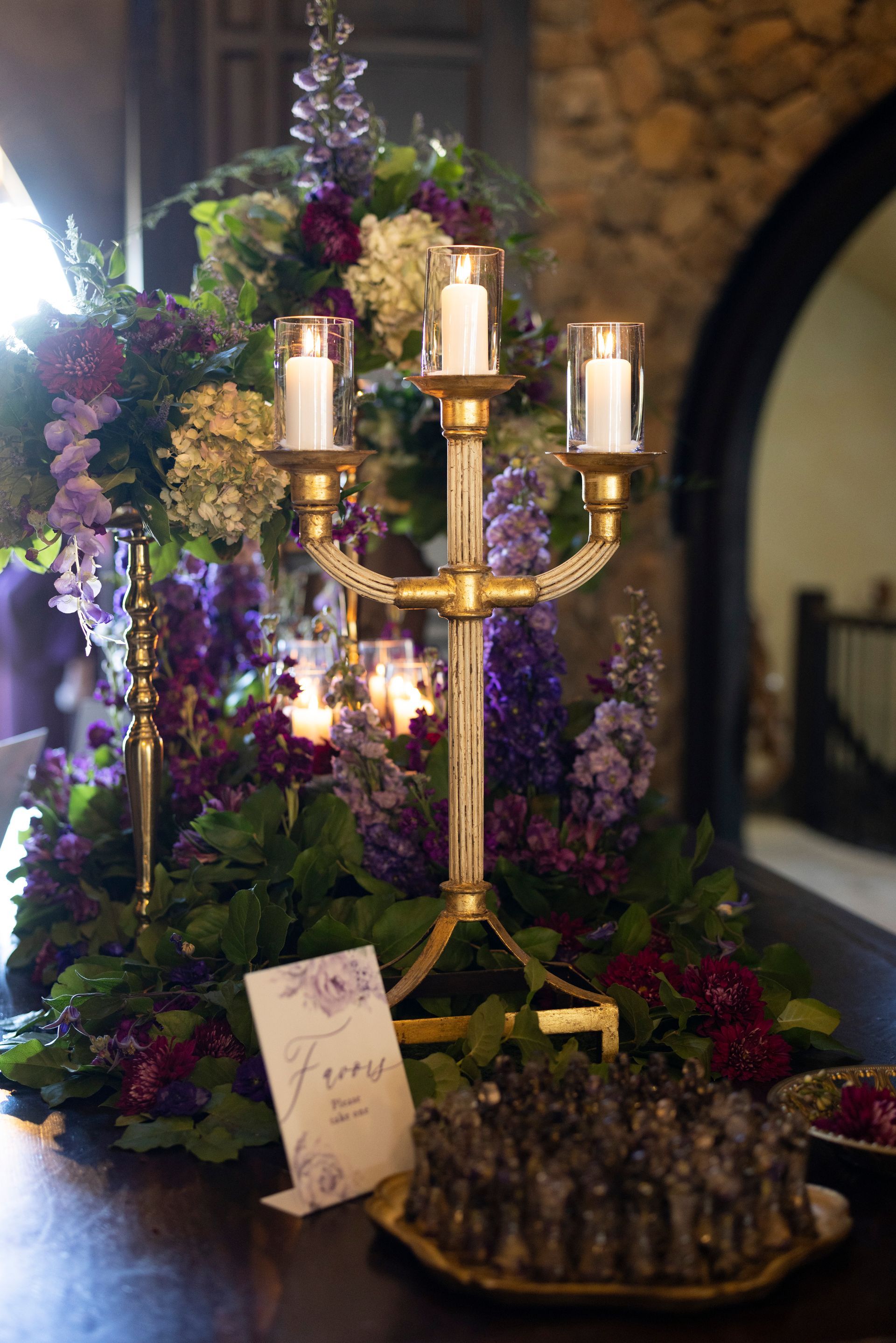 A candelabra with candles and flowers on a table.