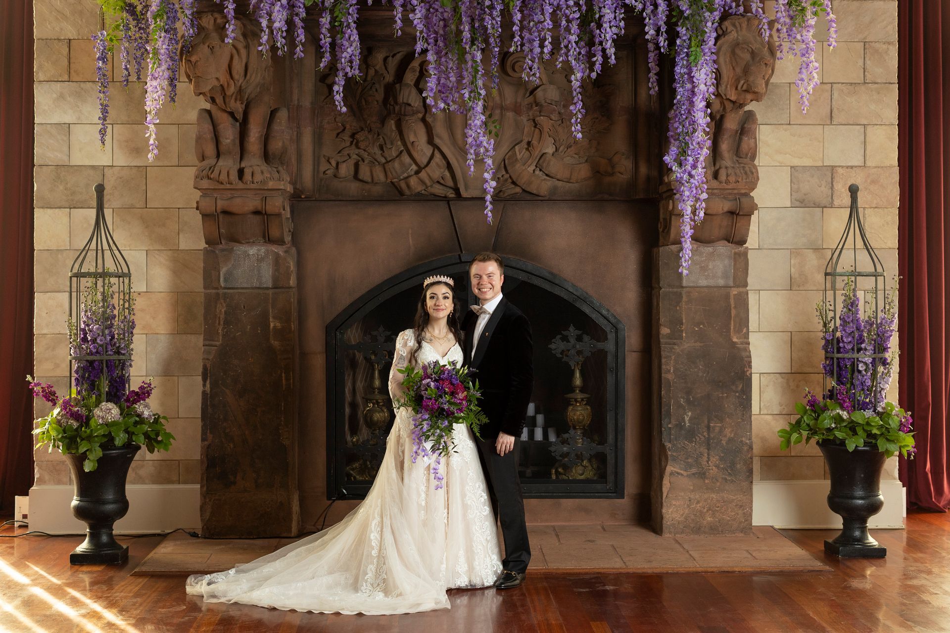 A bride and groom are posing for a picture in front of a fireplace.
