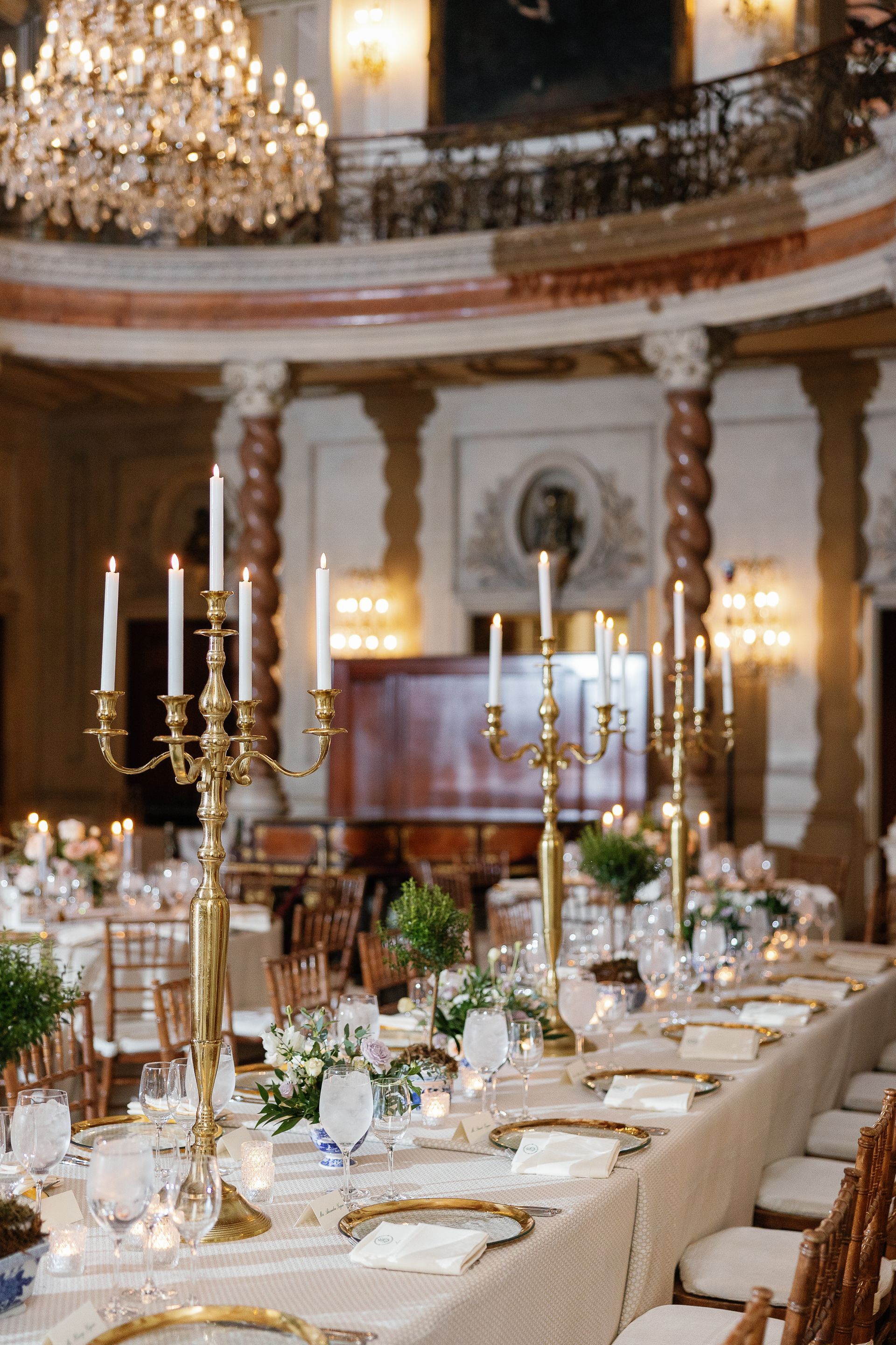 A long table with candles on it in a large room.