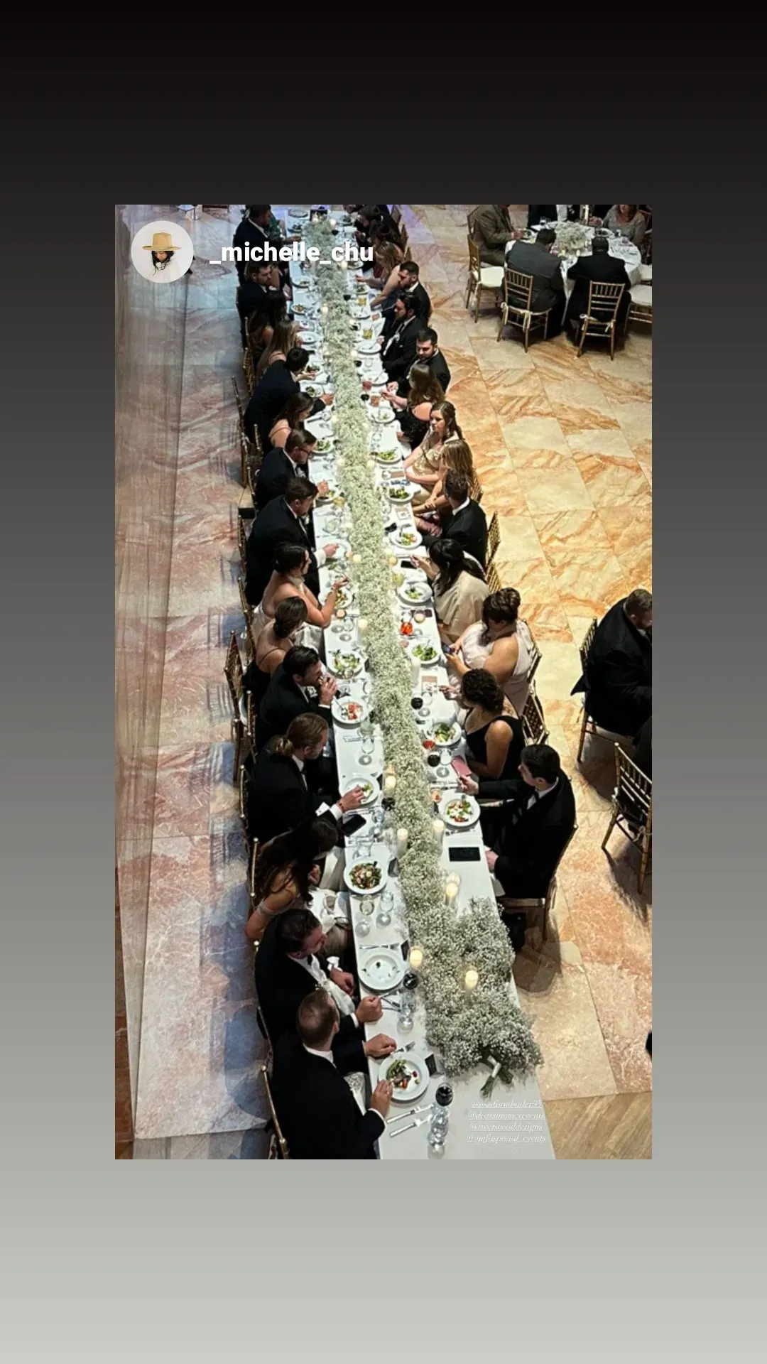 A group of people are sitting at a long table eating food.