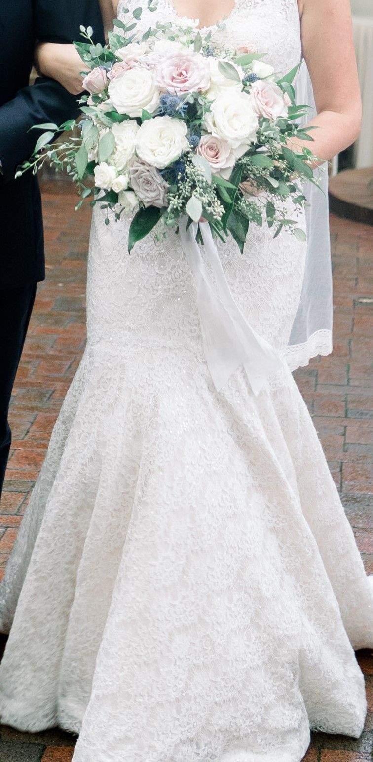 A bride in a white wedding dress is holding a bouquet of flowers.