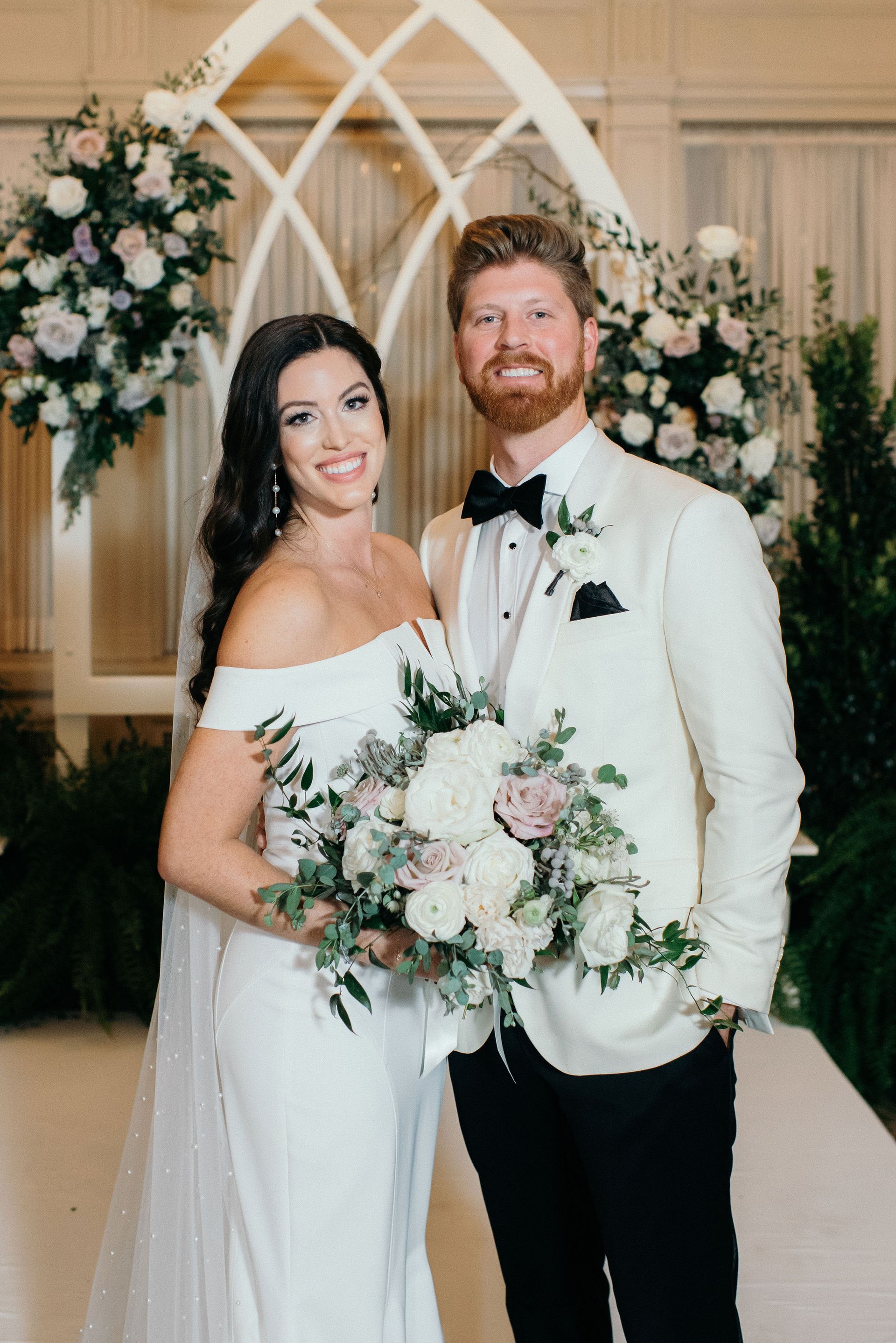 A bride and groom are posing for a picture at their wedding ceremony.