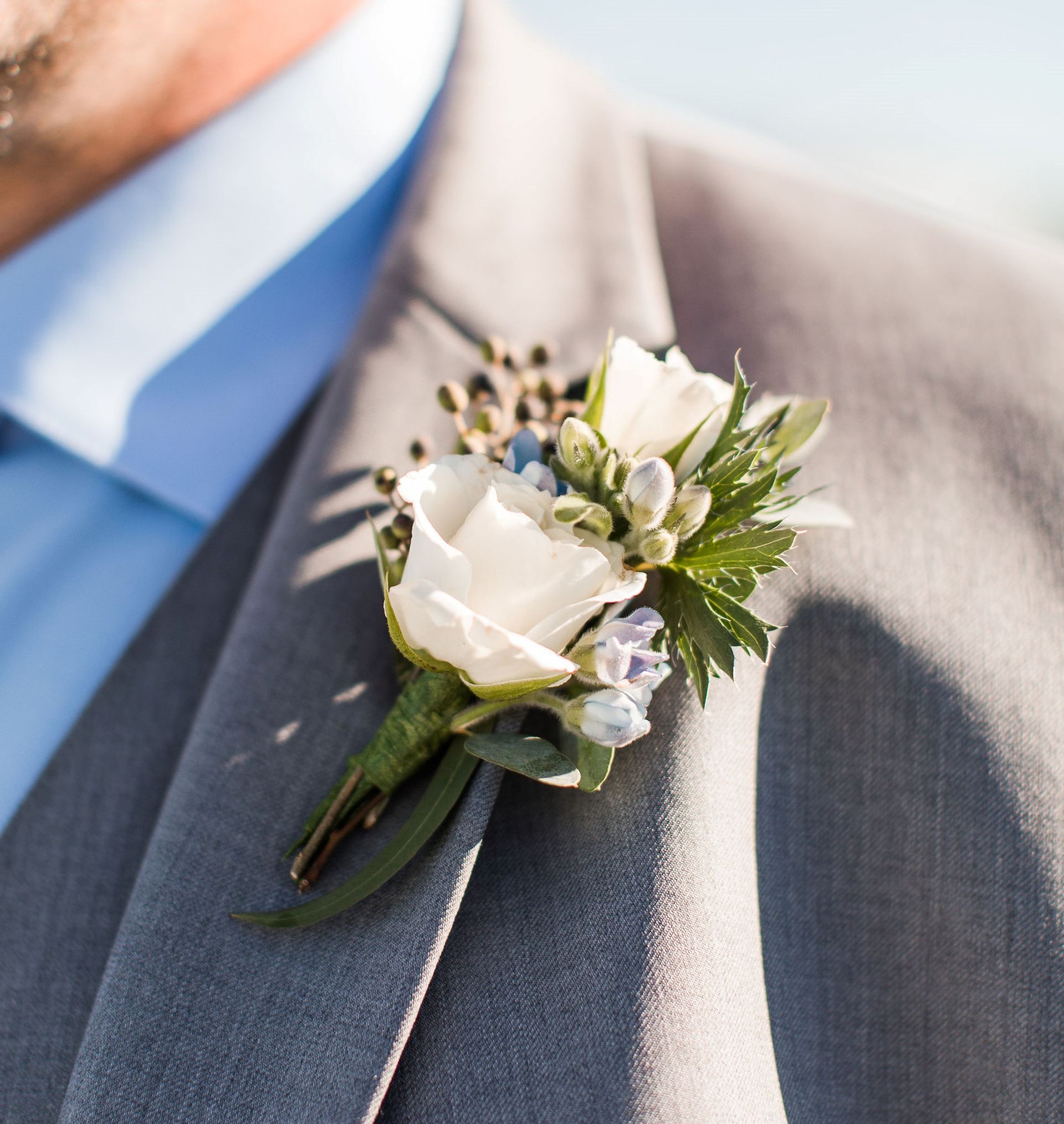 A man in a suit has a flower pin on his jacket