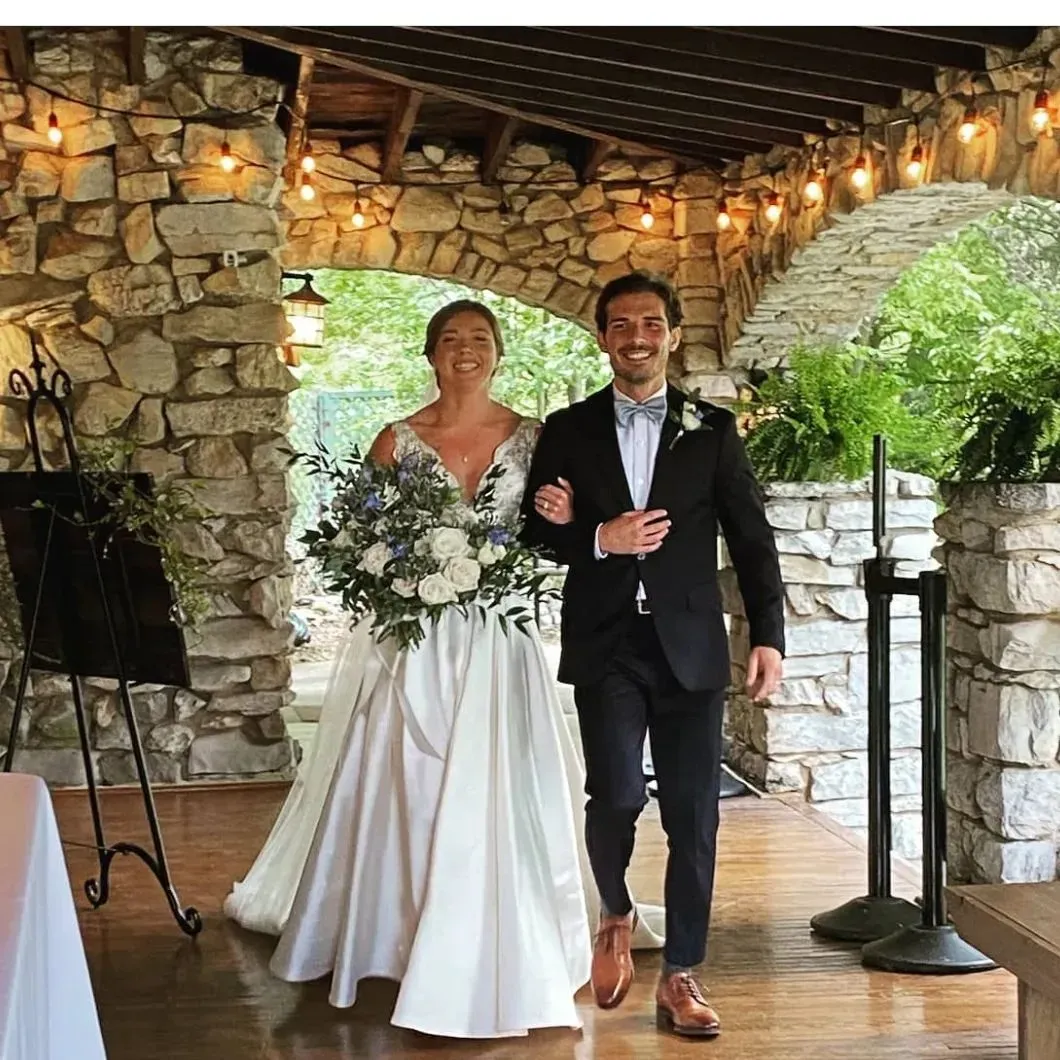 A bride and groom are walking down the aisle at their wedding.